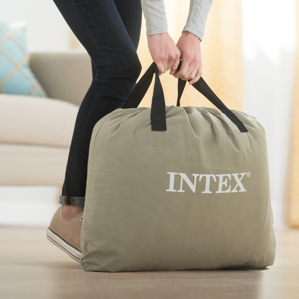 Osoba niosąca dużą, khaki torbę z logo INTEX.