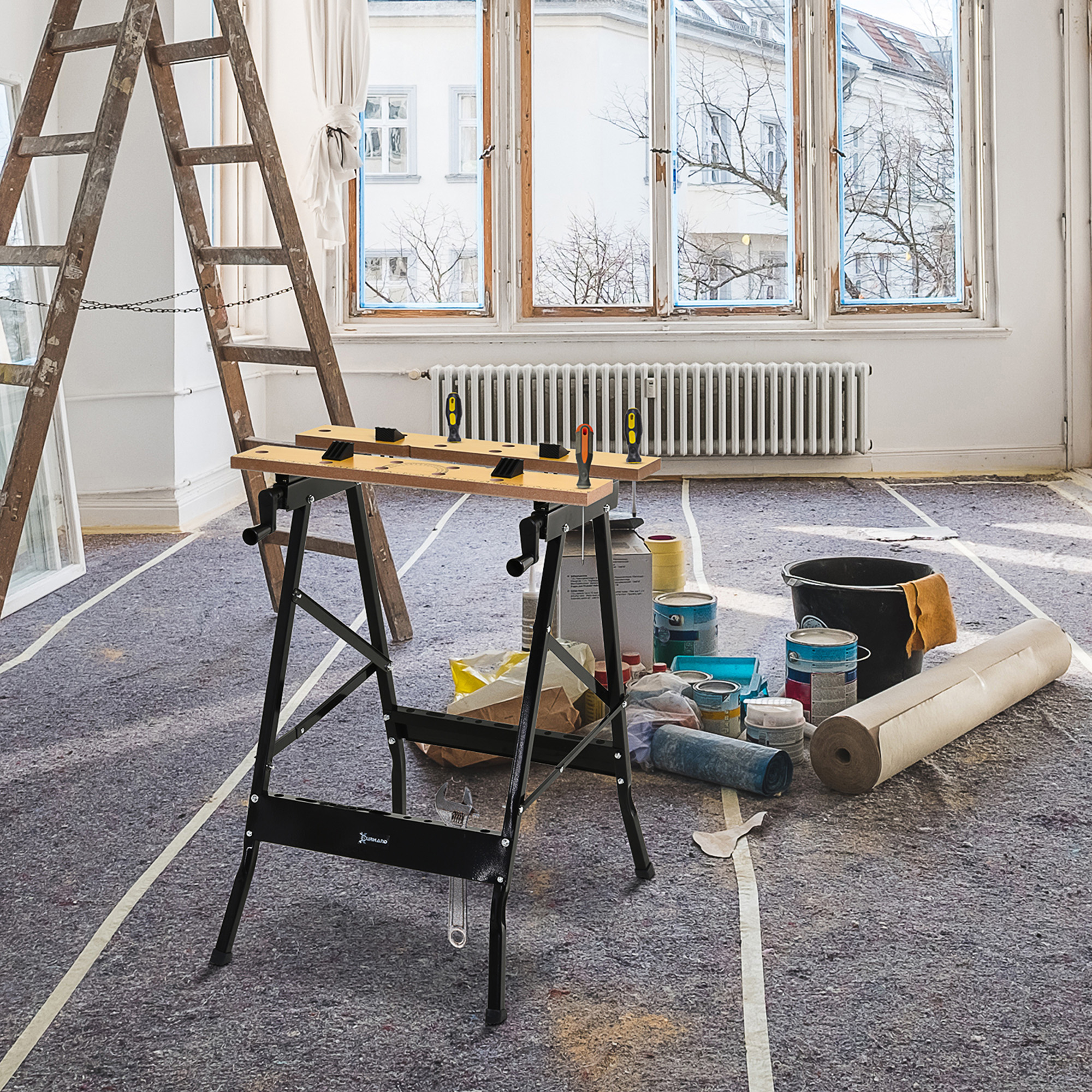 Montaje de taller con banco de trabajo plegable, escalera, latas de pintura y lonas.