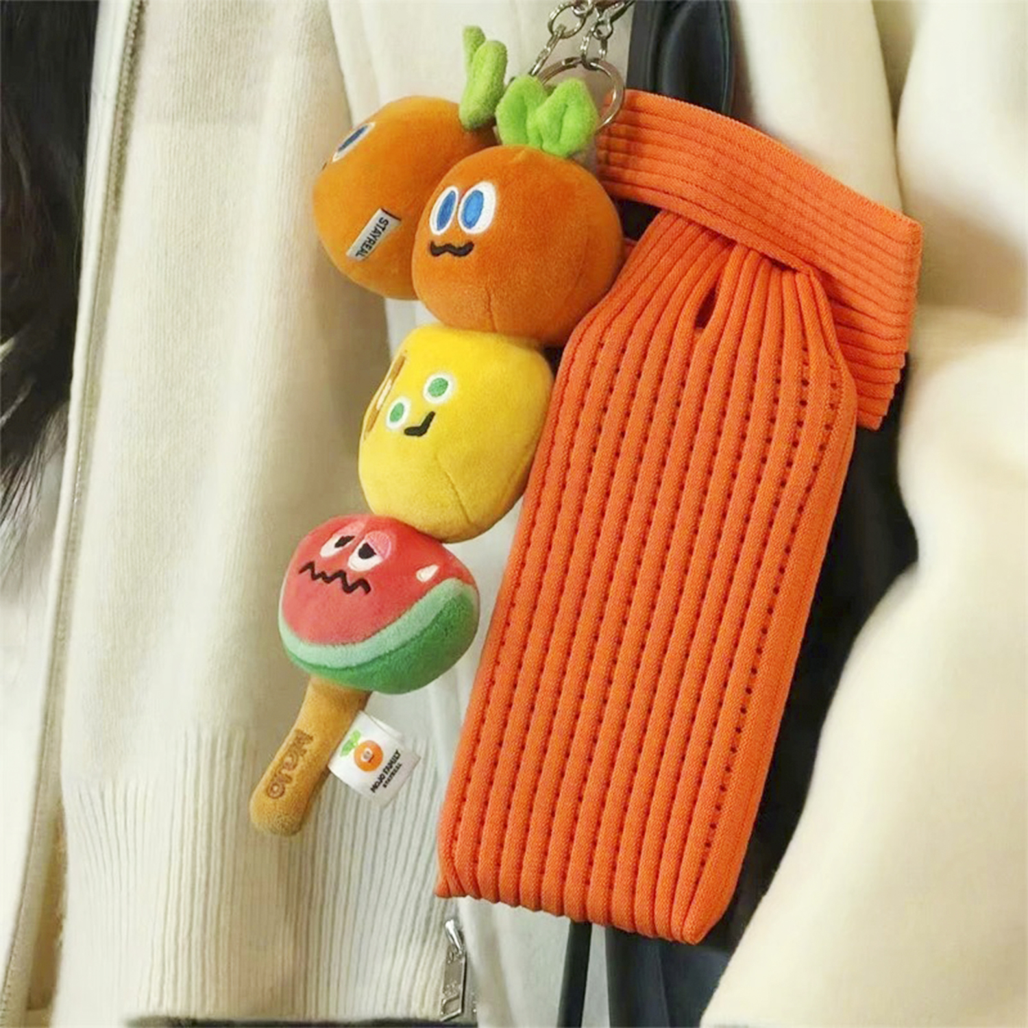 Charms di peluche: arancia, giallo e anguria su uno spago.