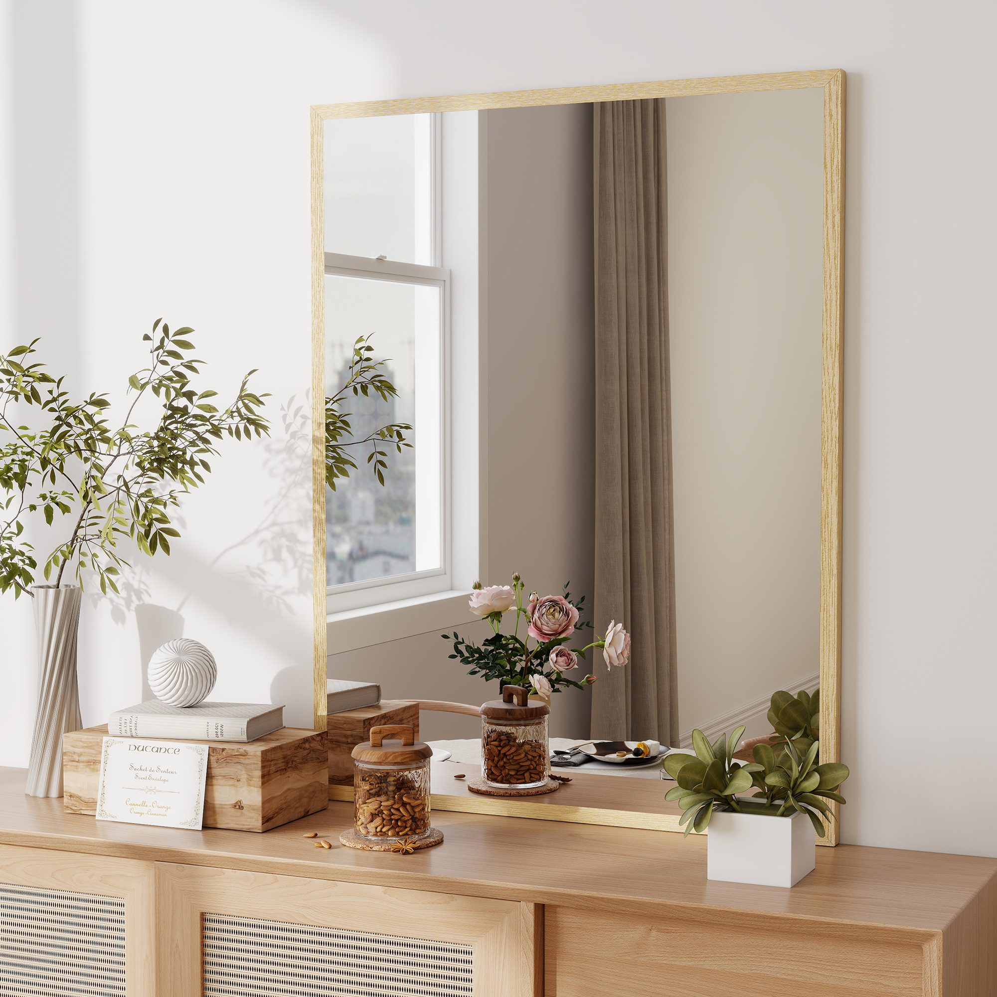 Cómoda de madera con espejo, jarrón, libros y flores. Vista interior.