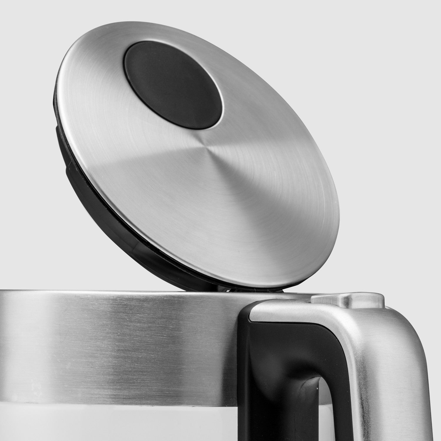 A silver kettle lid with a black button is open.