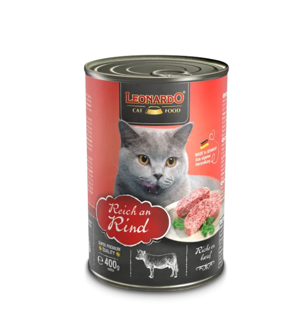 Una lata de comida para gatos con un gato gris lamiéndose los labios. Se muestran carne de res y perejil.