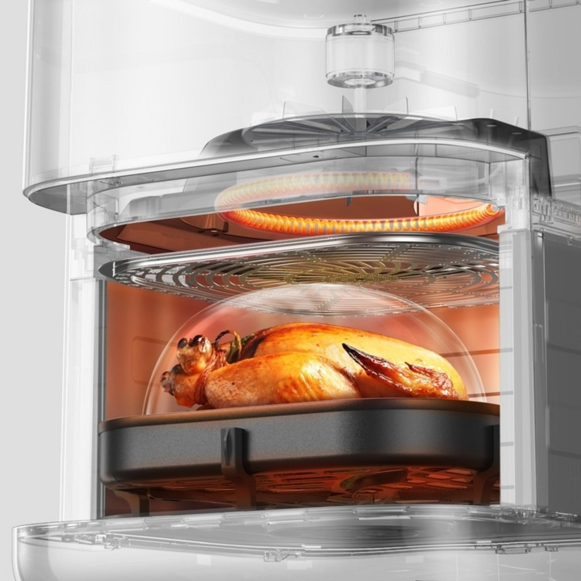 Pieczony kurczak w przezroczystym piekarniku z żarzącymi się elementami grzewczymi u góry.