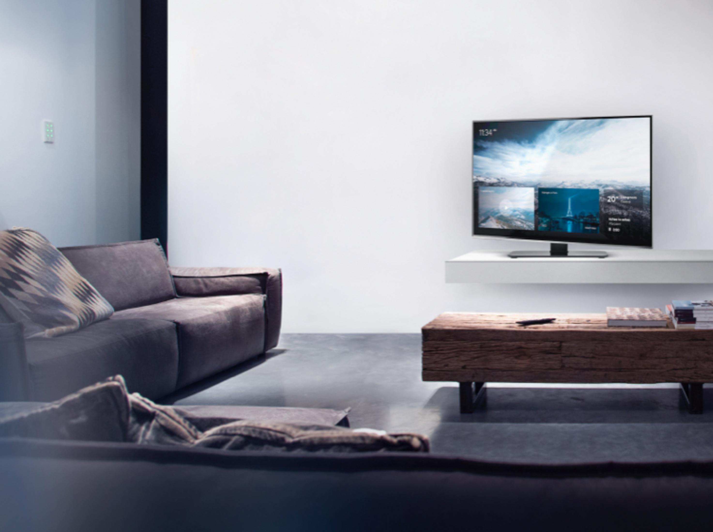 Donkergrijze bank in een moderne woonkamer met een tv-scherm.