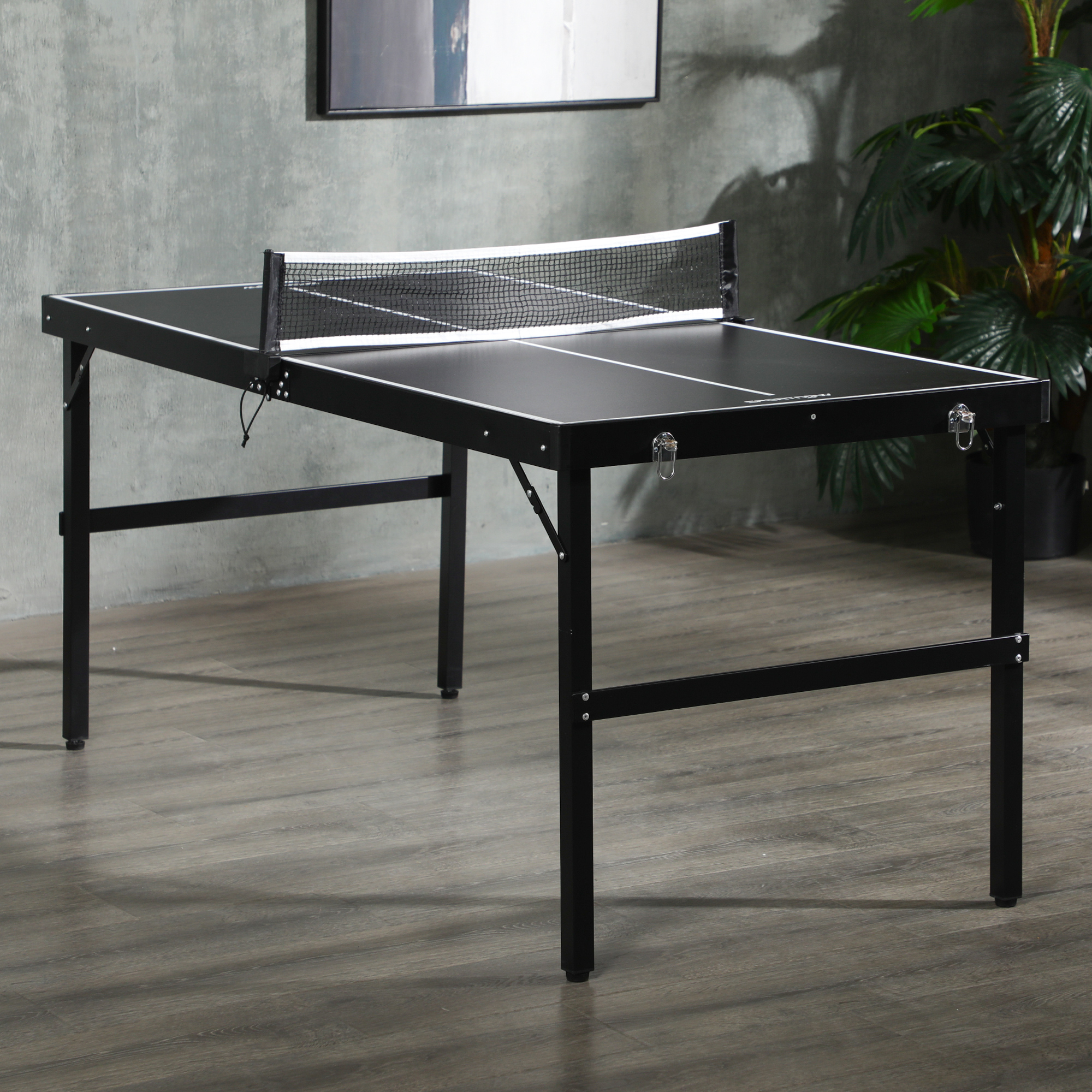 Mesa de ping pong negra con red, sobre suelo de madera.