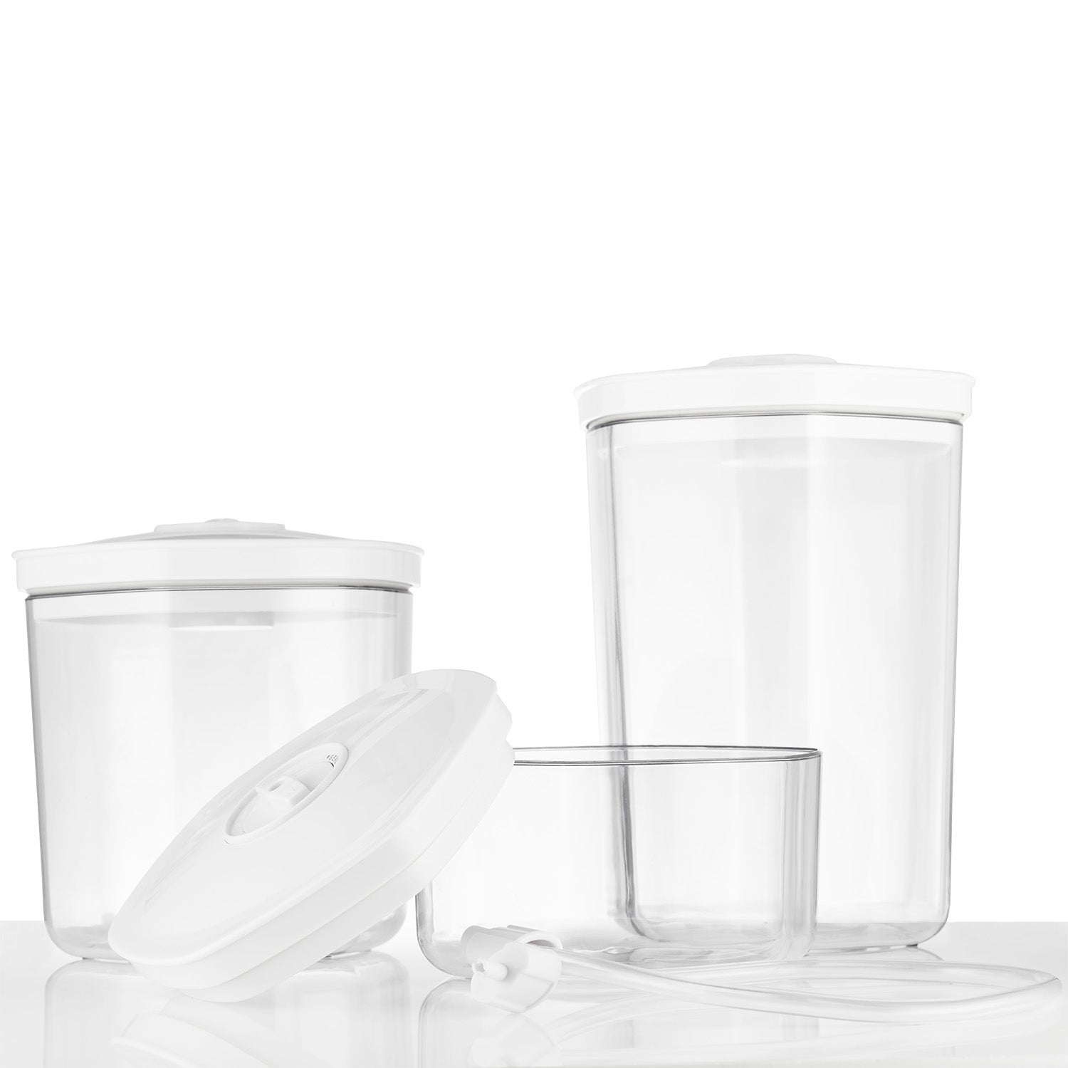 Drie doorzichtige containers met witte deksels, één ligt vooraan.