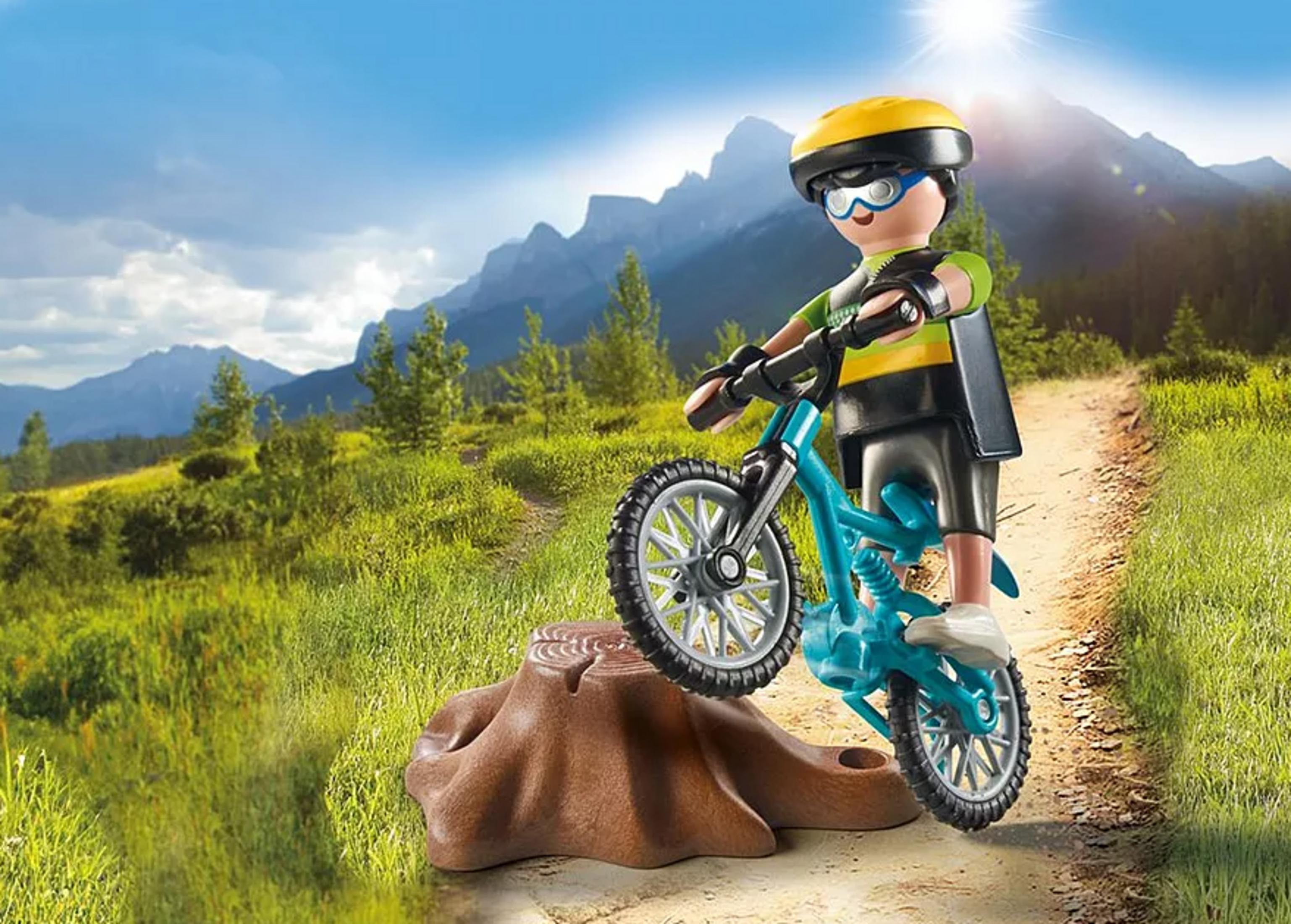 Un ragazzo in bicicletta supera un ceppo in montagna.