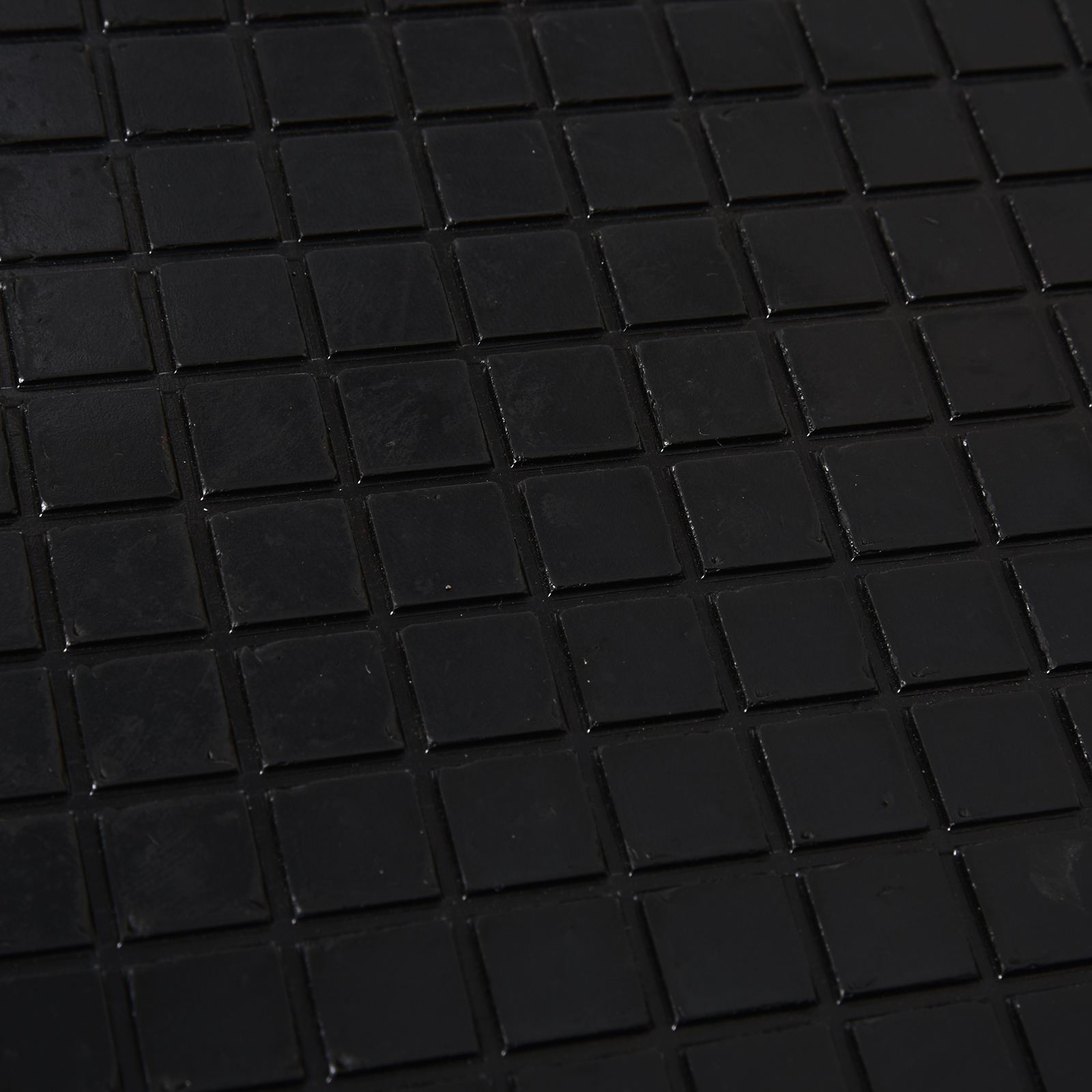 Azulejos negros y brillantes en patrón de rejilla, vista cercana.