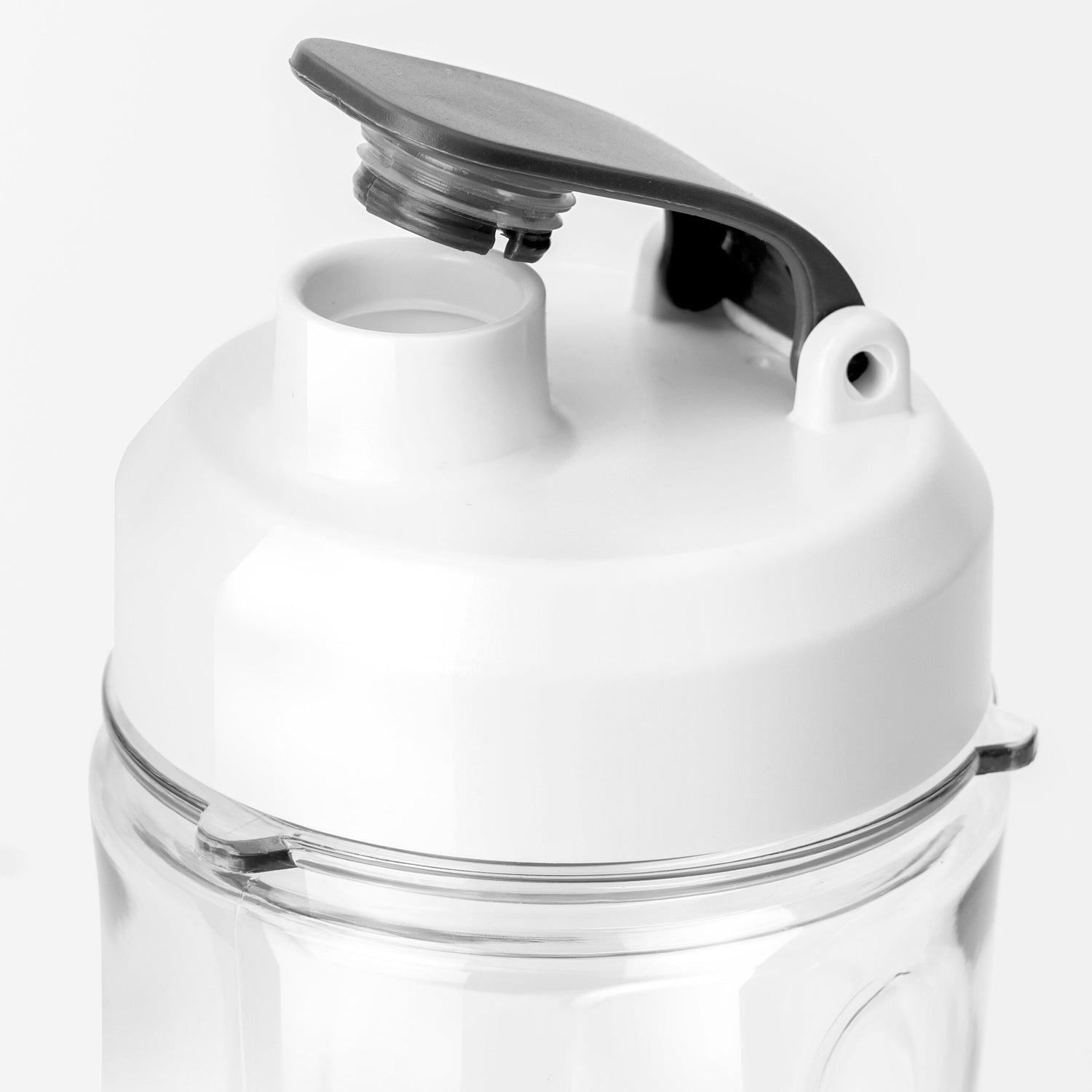 Close-up of the open lid of a white and clear threaded bottle.