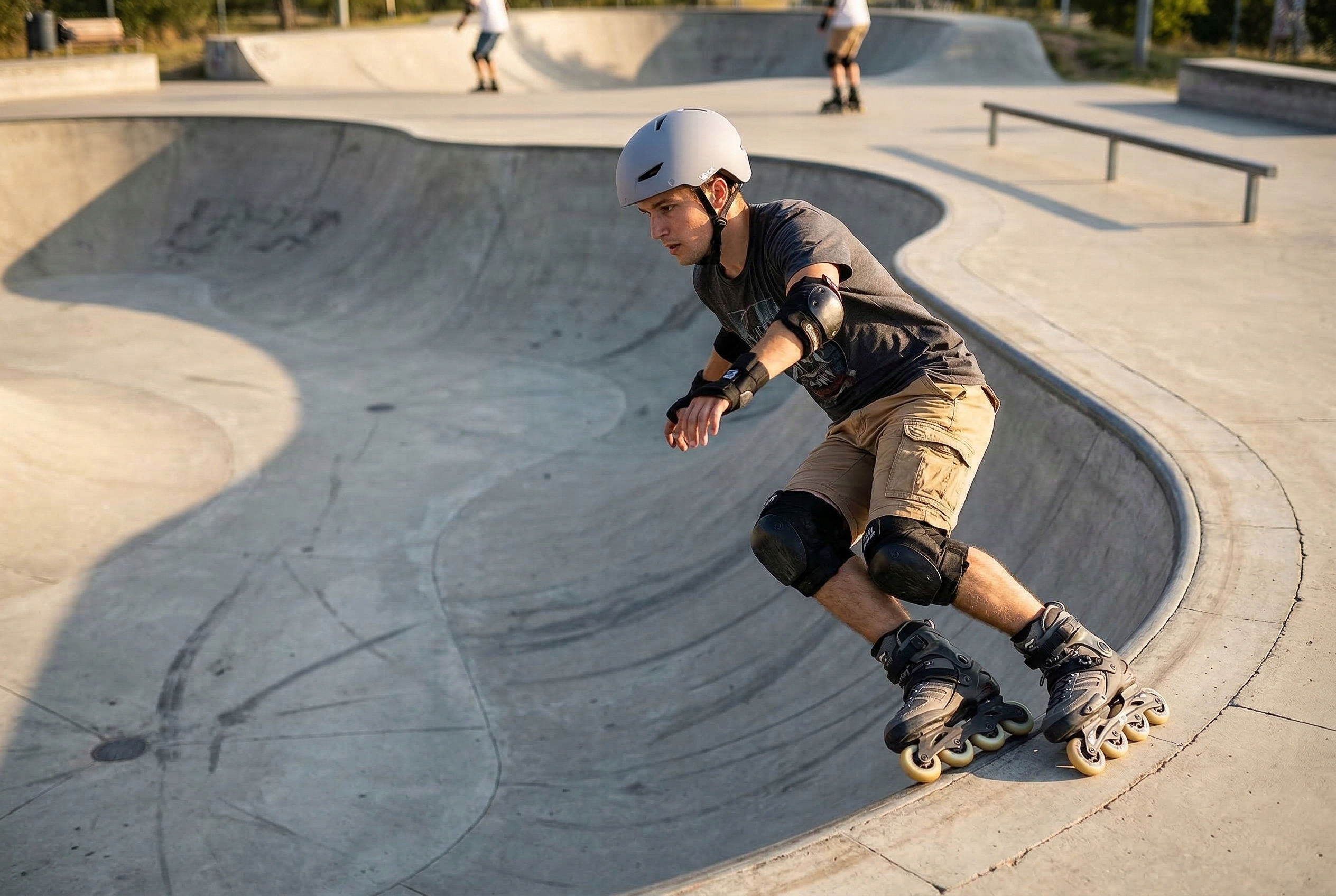 Mężczyzna w sprzęcie ochronnym jeździ na rolkach w betonowym skateparku.