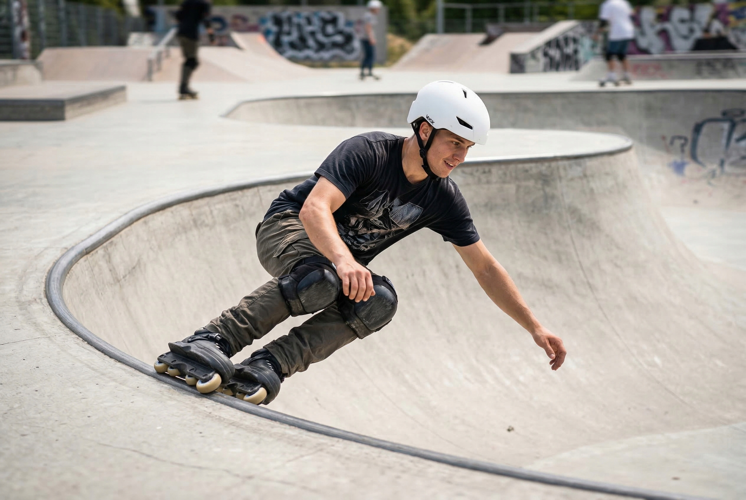 Mężczyzna w kasku jeździ na rolkach w betonowym skateparku, nosząc ochraniacze.
