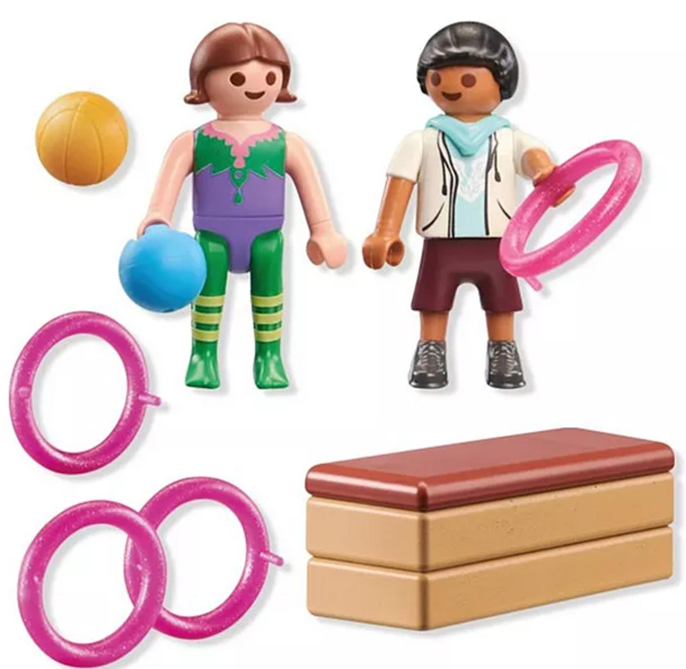 Zwei Playmobil-Figuren mit Sportgeräten, darunter ein Ball, Ringe und ein Kasten.