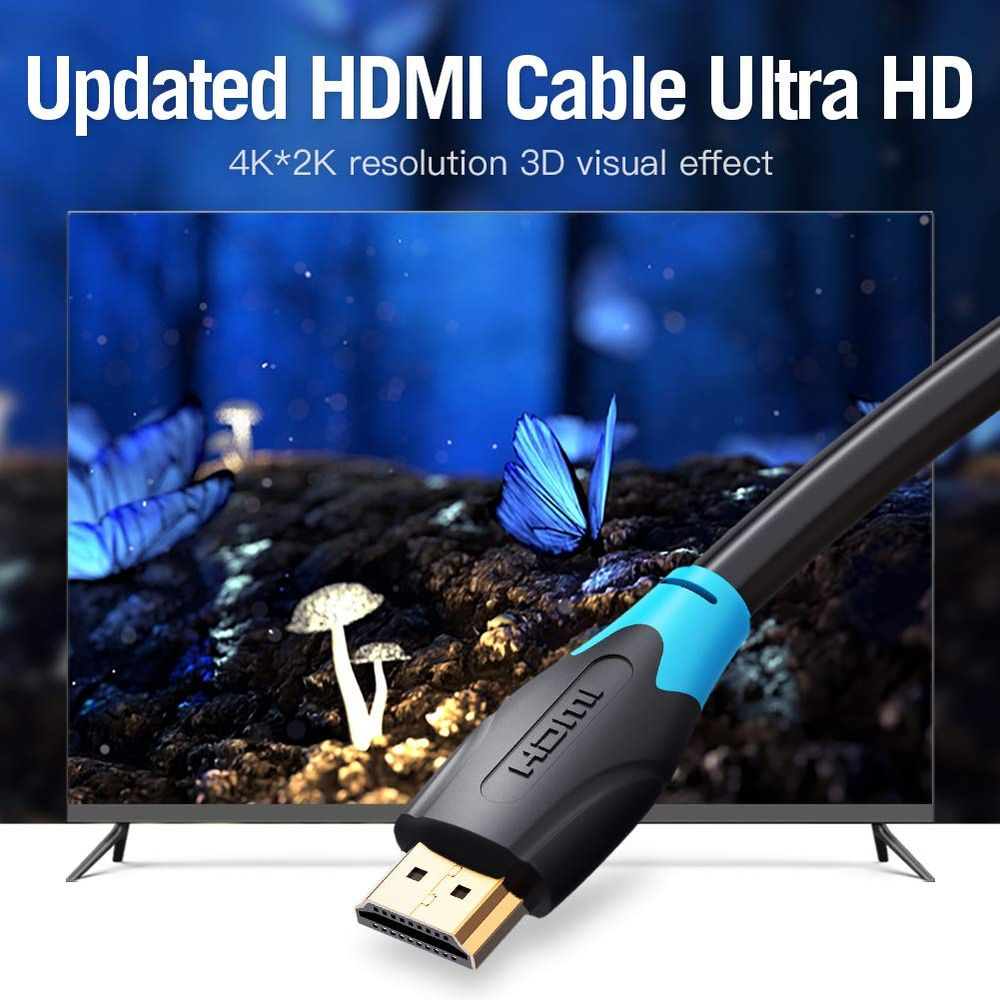 Un cavo HDMI davanti a uno schermo 4K che mostra farfalle e funghi.