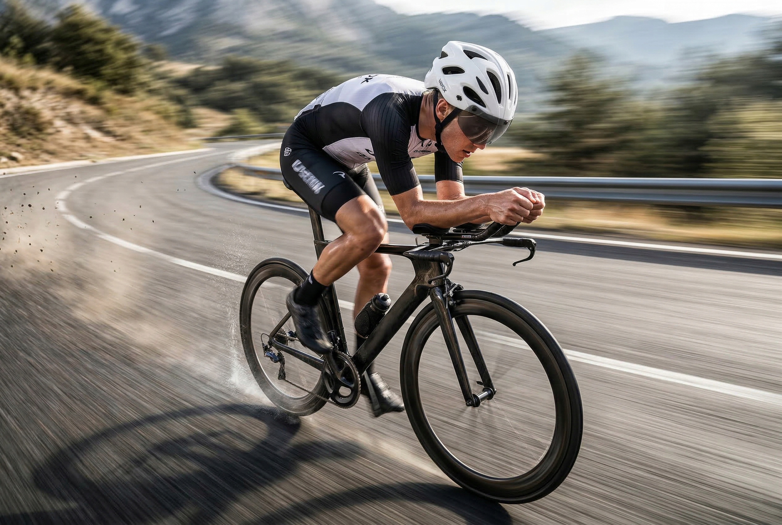 Kolarz pędzi krętą drogą z drzewami i górami w tle.