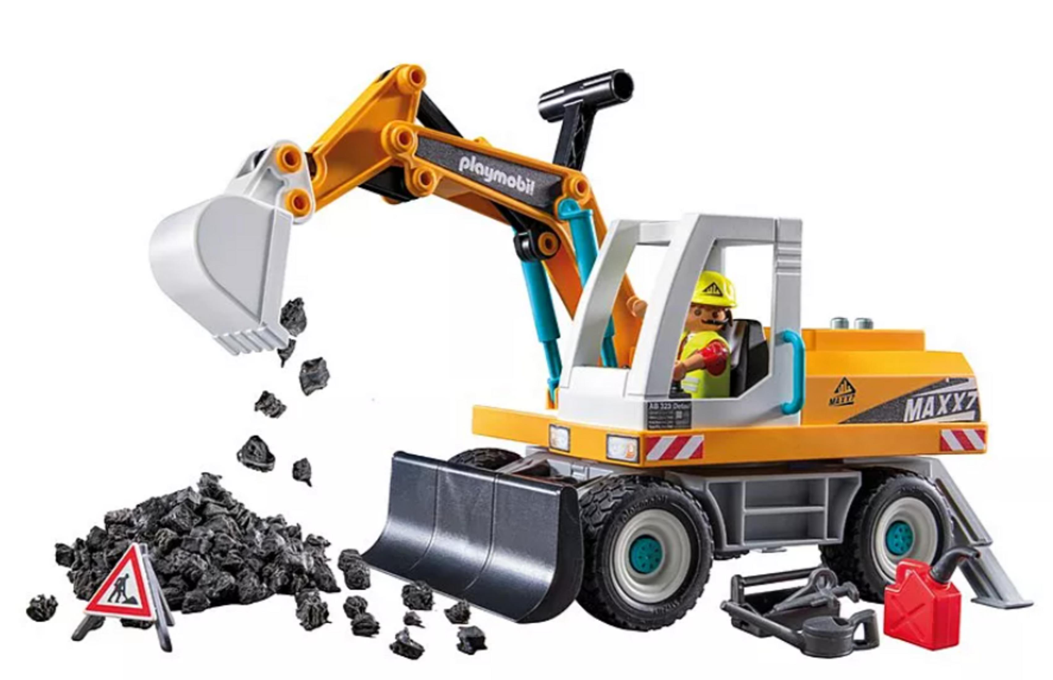 Una excavadora de juguete amarilla con un conductor, recogiendo escombros. Hay un cartel y un bidón cerca.