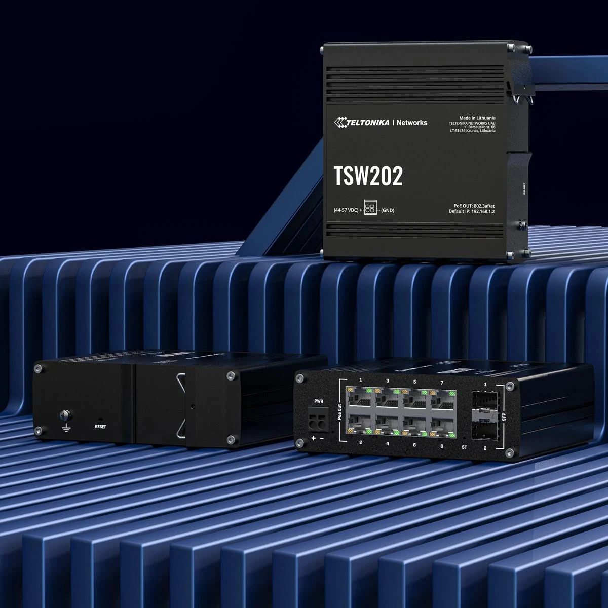 Trzy czarne przełączniki sieciowe na niebieskiej, żebrowanej powierzchni.