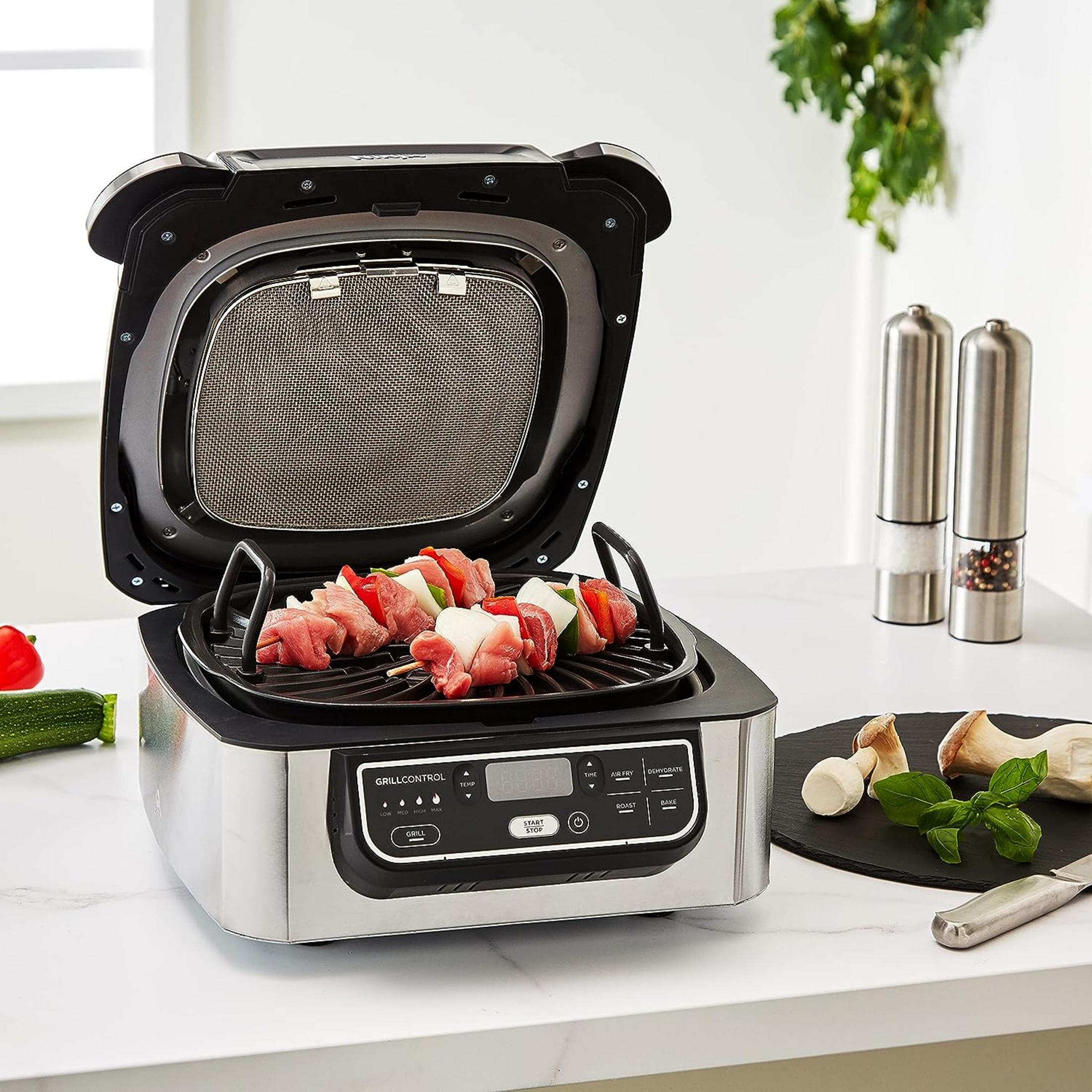 Otwarty grill z szaszłykami mięsnymi i warzywnymi. W pobliżu młynki do przypraw i grzyby.