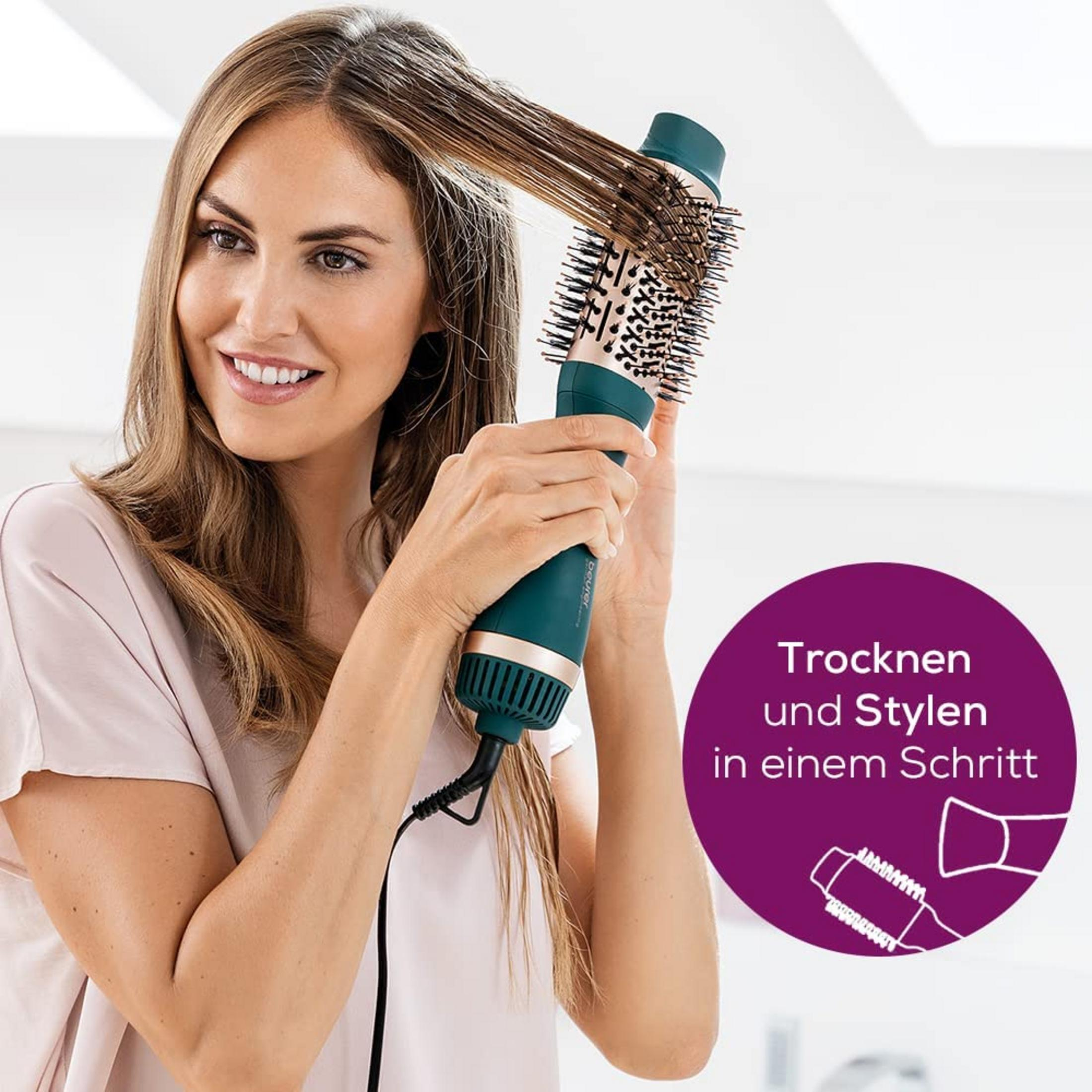 Mujer secando y peinando su cabello con un secador de cepillo giratorio dorado y verde azulado.