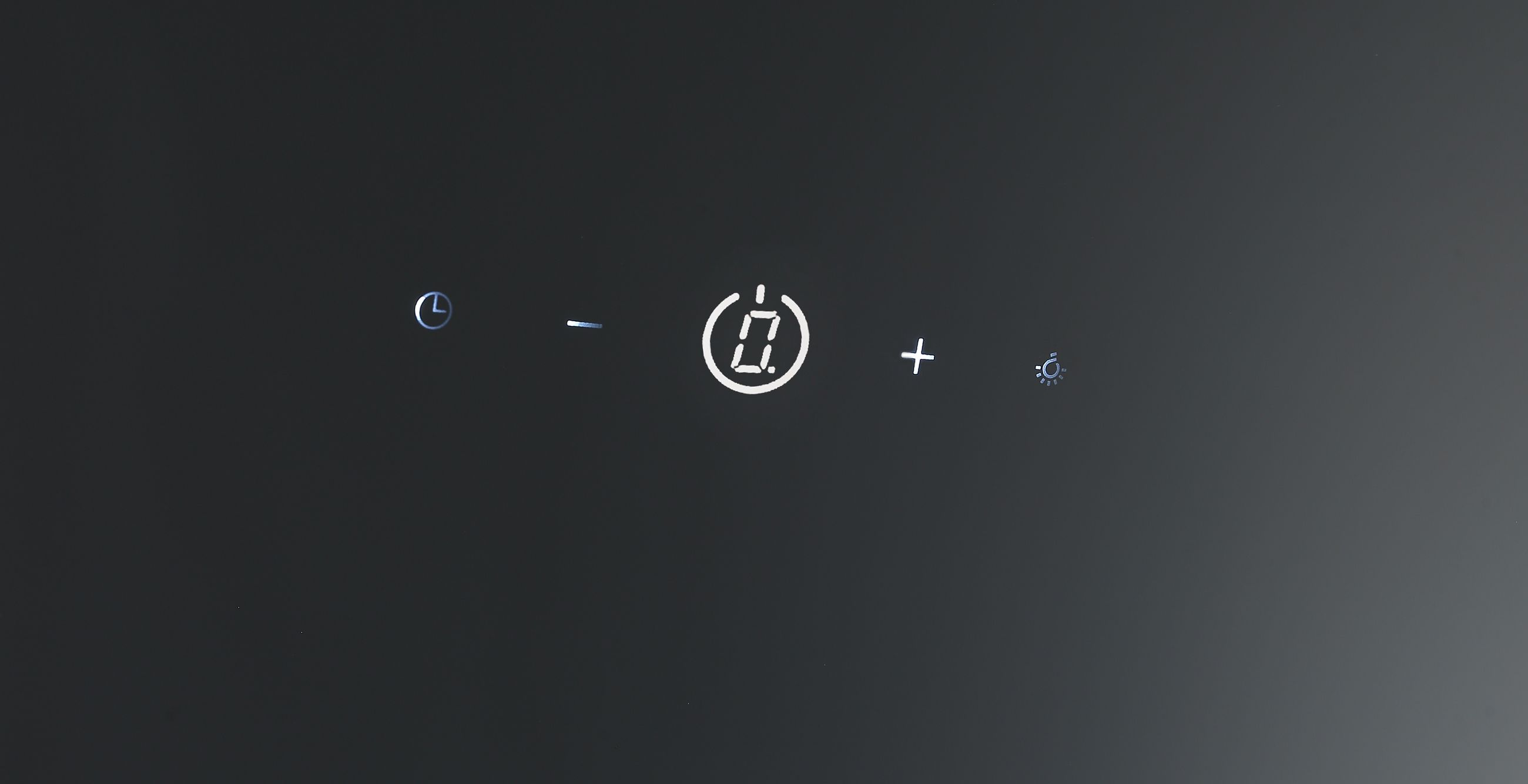 Digitalanzeige mit Timer, Minus, Plus und Lichtsymbol auf schwarzem Hintergrund.