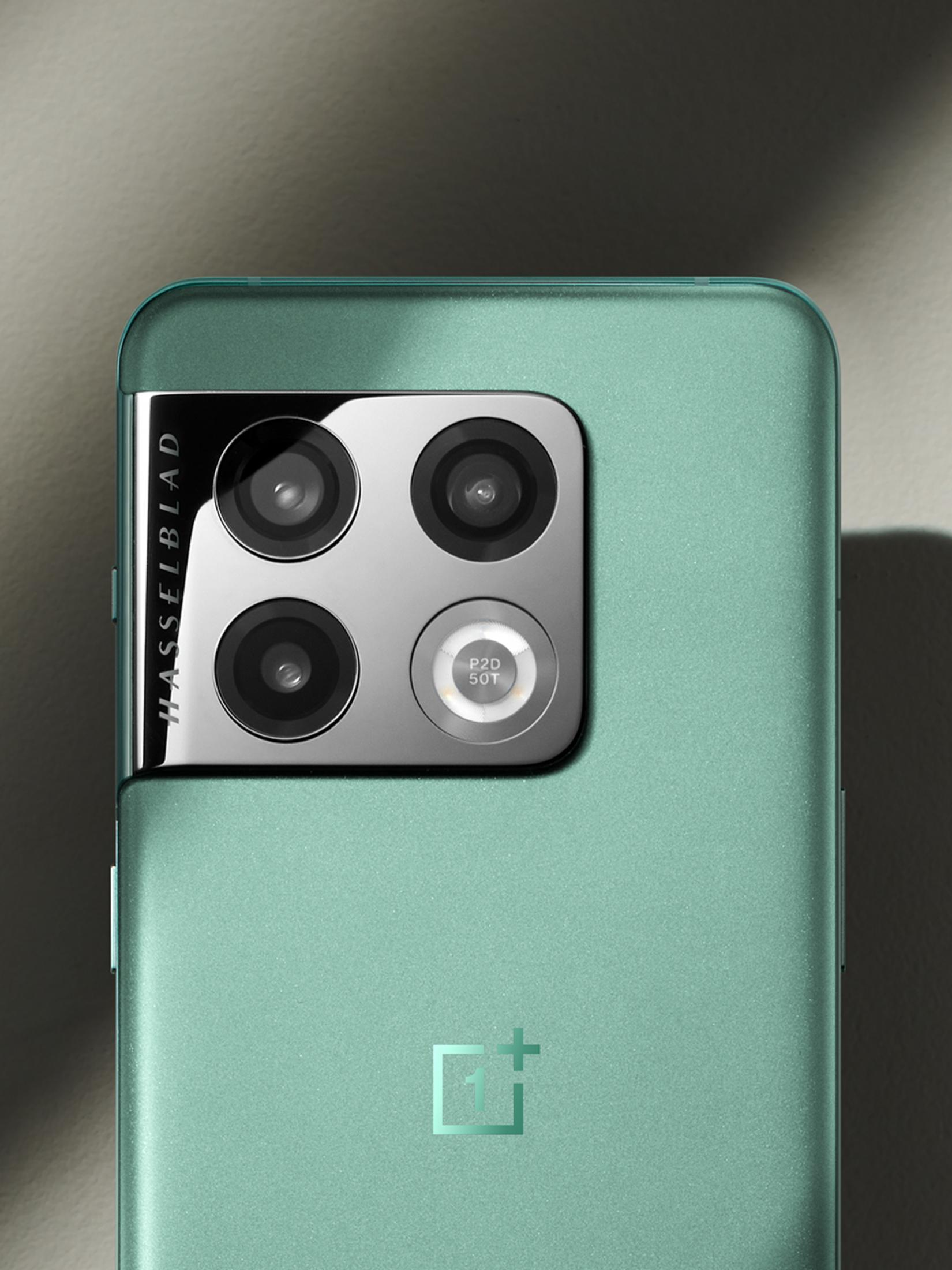 Rückseite eines türkisfarbenen Smartphones mit Hasselblad-Kamera und OnePlus-Logo.