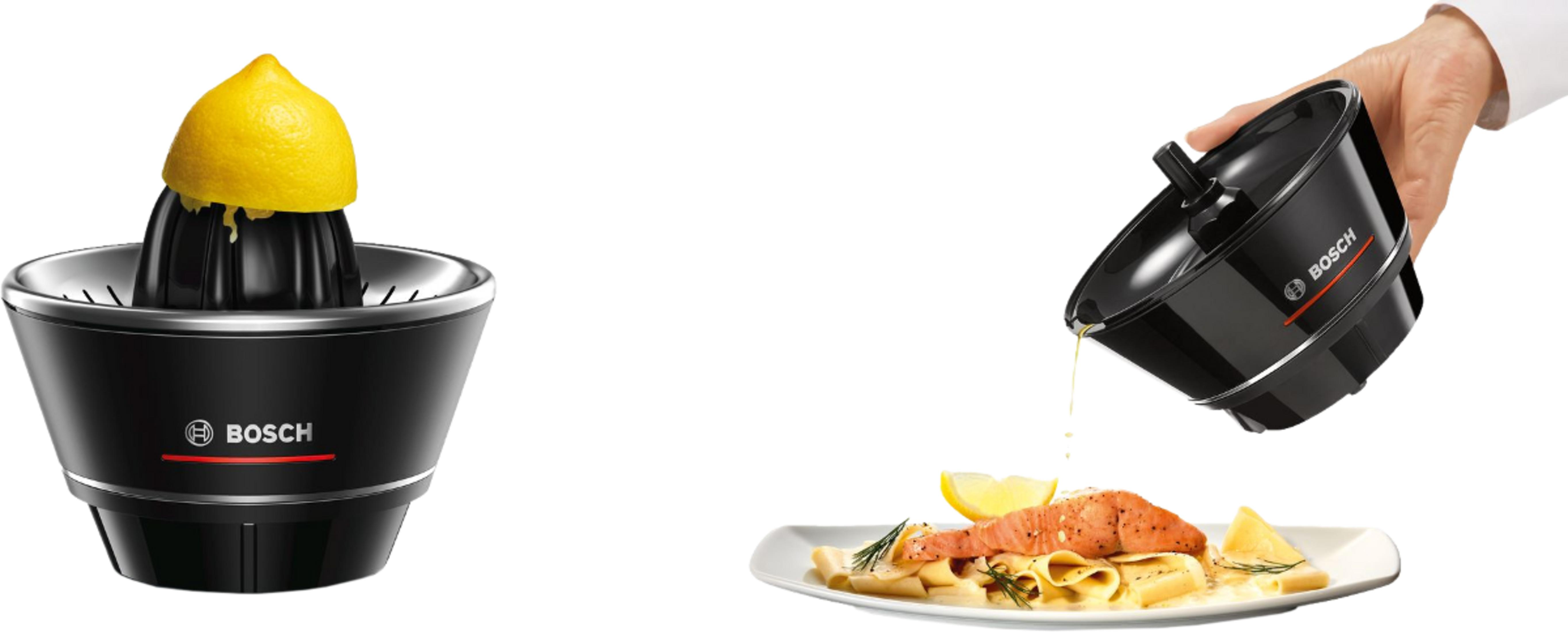 Czarna wyciskarka do cytrusów Bosch z cytryną i kucharz polewający łososia sokiem.