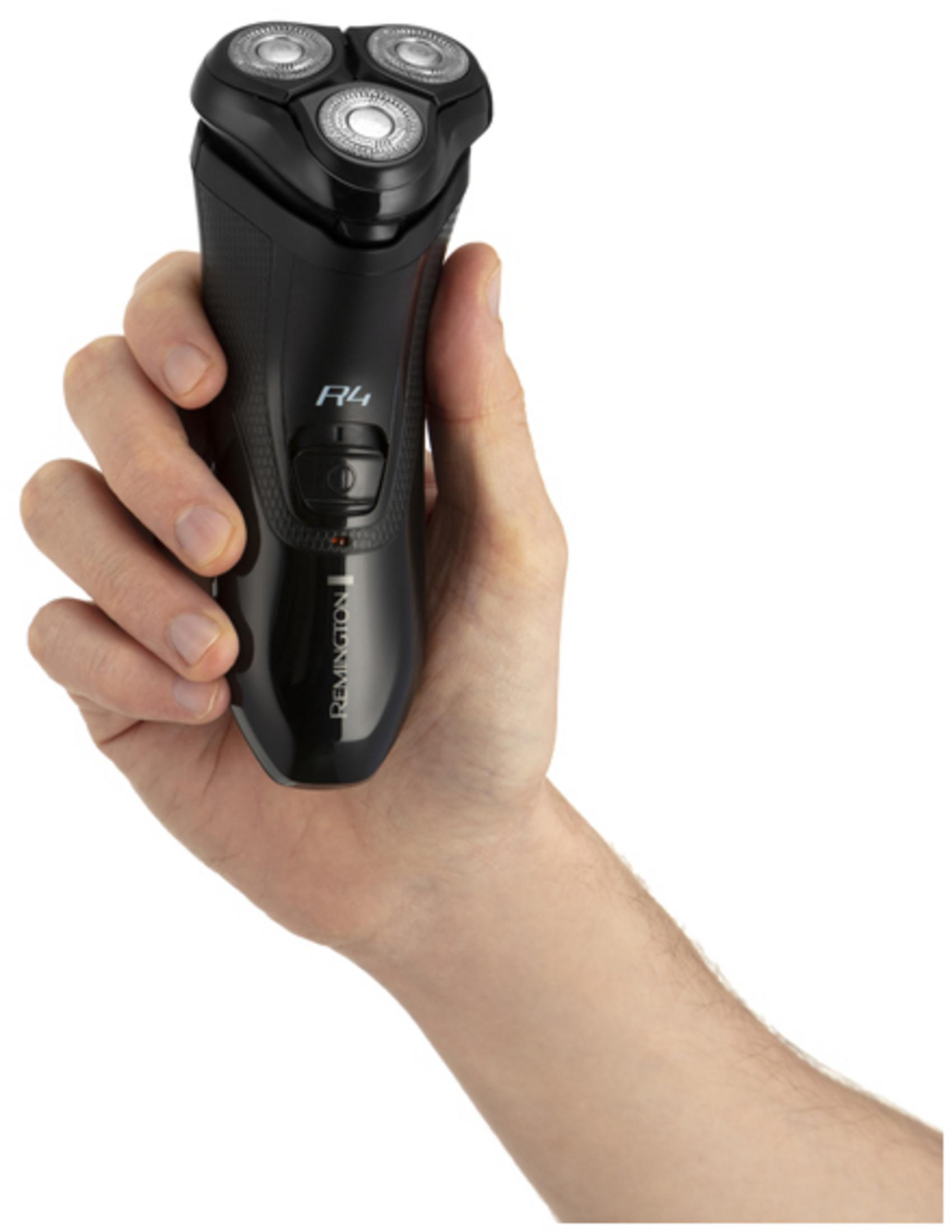Eine Hand hält einen schwarzen Remington Rotationsrasierer mit drei Klingensymbolen.