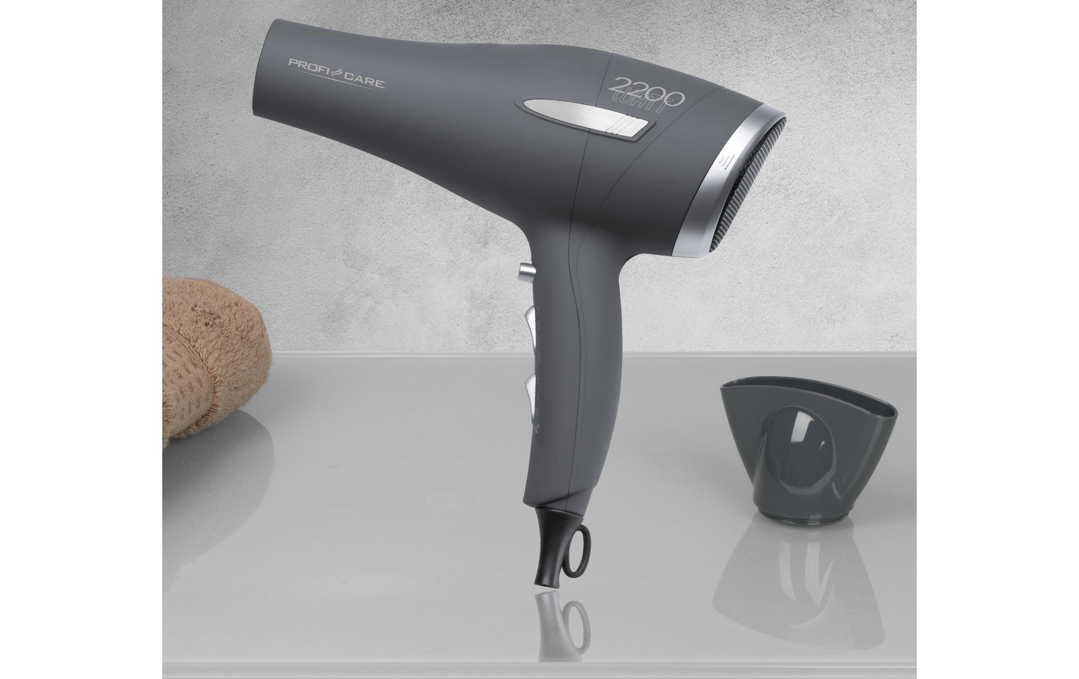 Szara suszarka do włosów z dyfuzorem i ręcznikiem na gładkiej powierzchni.