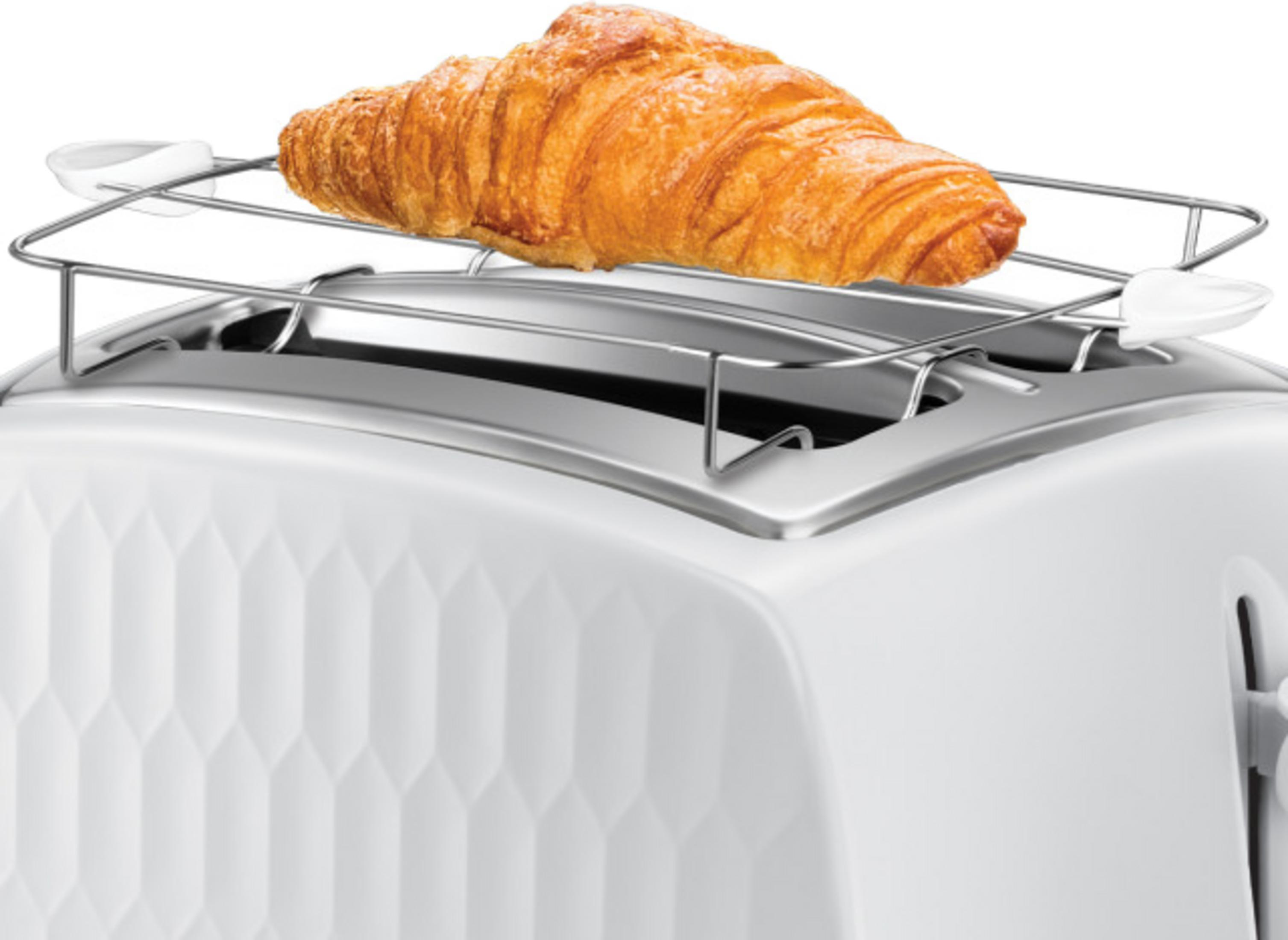 Złocisty rogalik leży na podgrzewaczu nad białym tosterem.