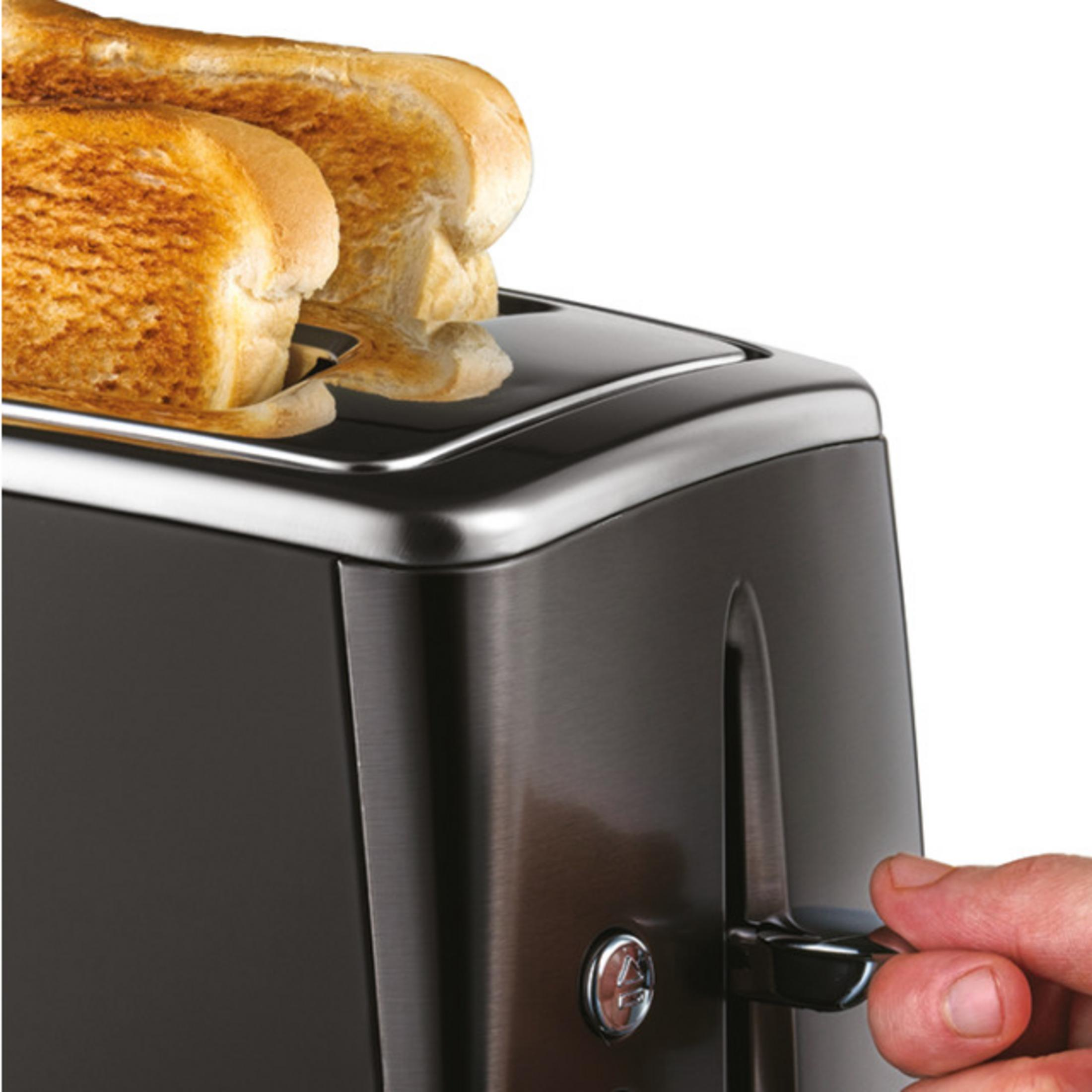 Ein Mann bedient einen Toaster mit zwei goldenen Toastscheiben.
