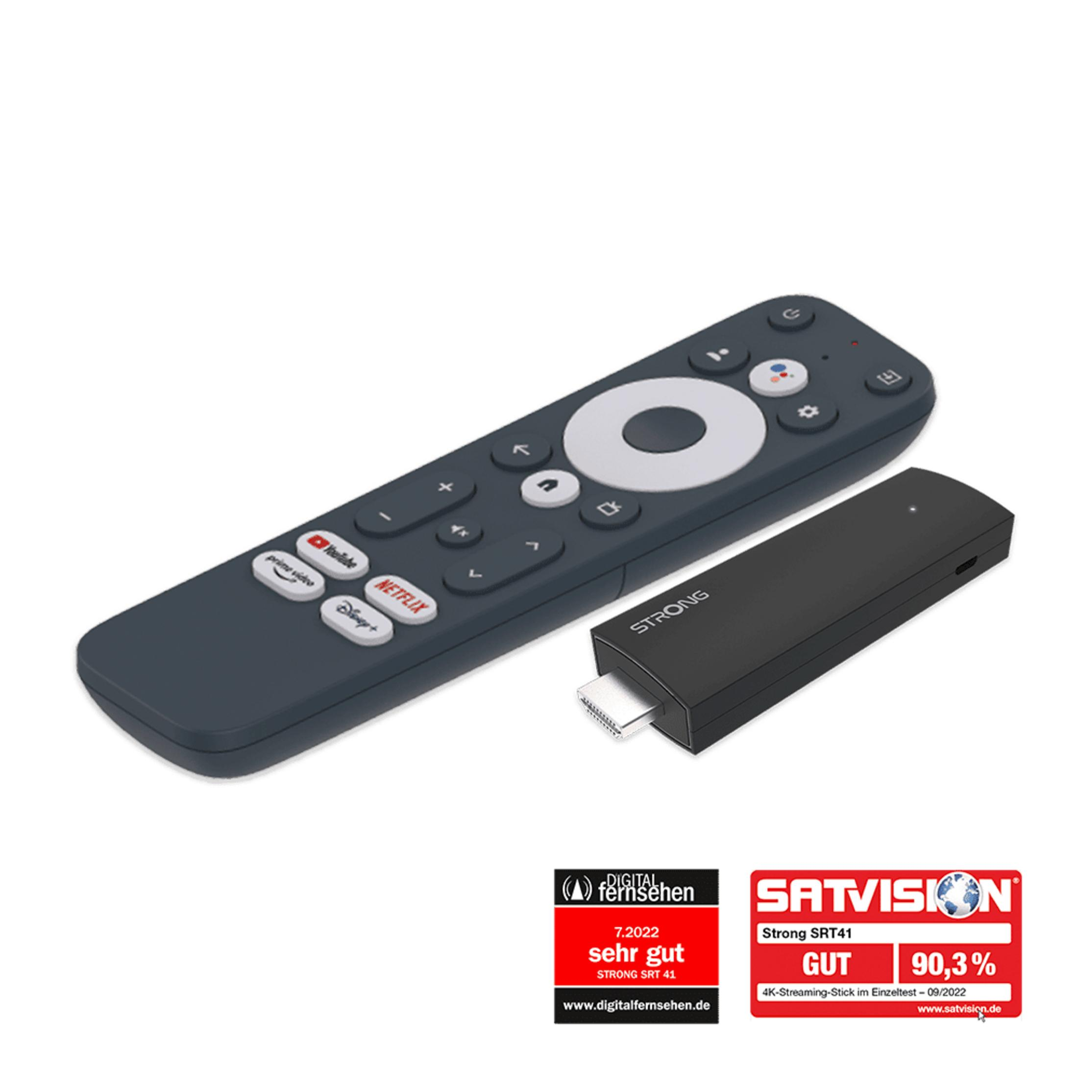 Ein schwarzer Streaming-Stick und eine Fernbedienung mit App-Tasten liegen nebeneinander.