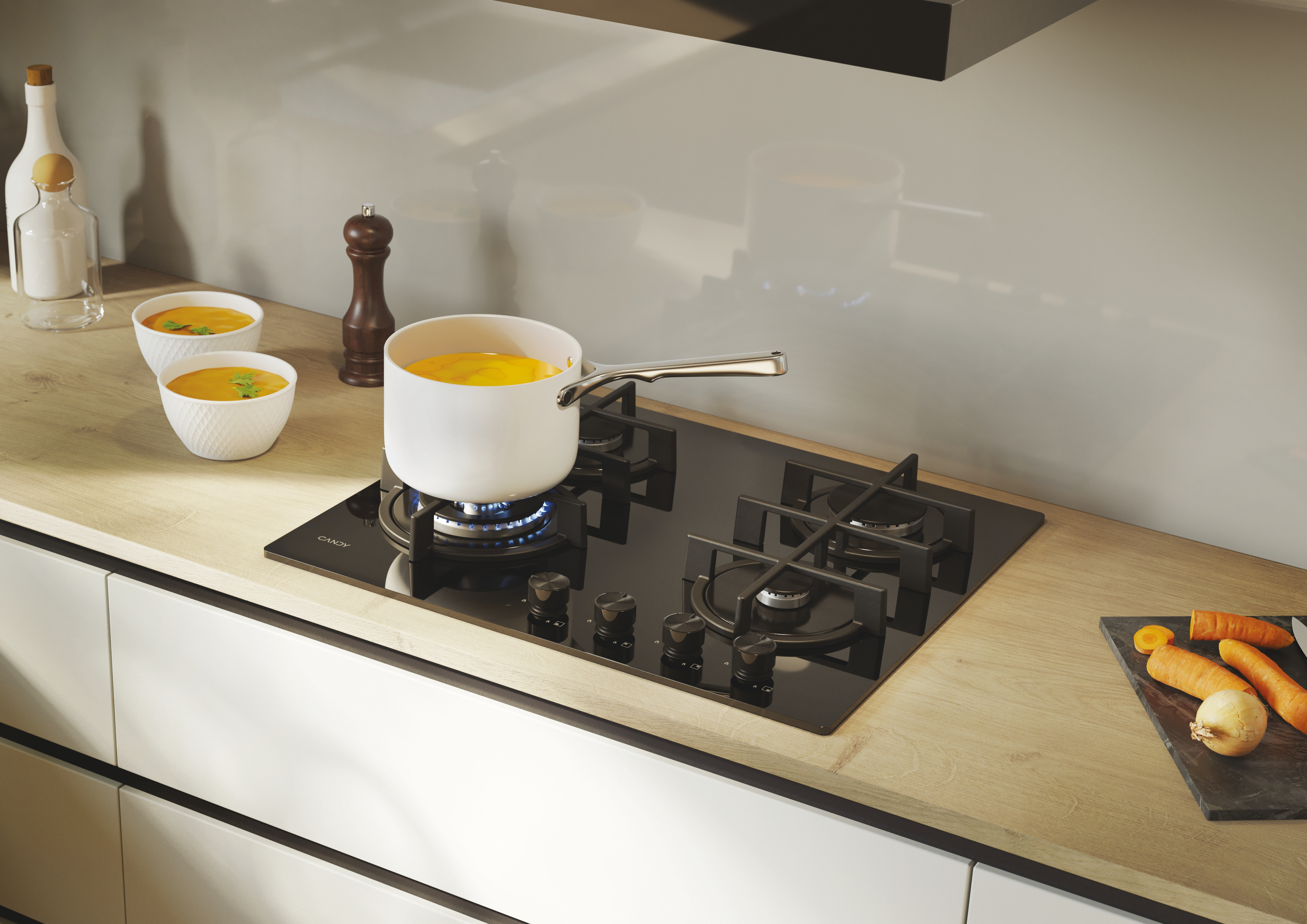 Una olla de sopa amarilla se cocina en una estufa de gas. Hay cuencos y saleros cerca.
