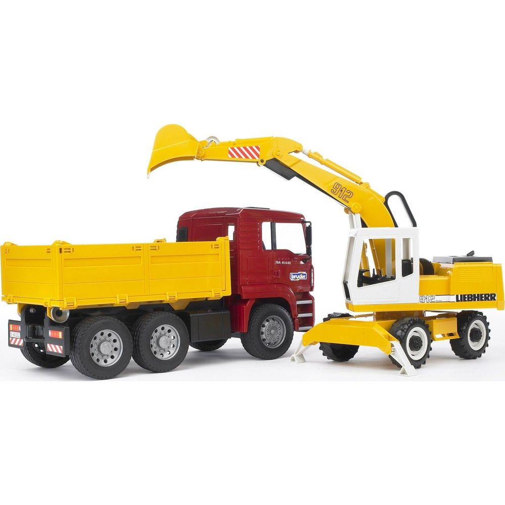 Czerwona ciężarówka z żółtą skrzynią obok żółtej koparki.