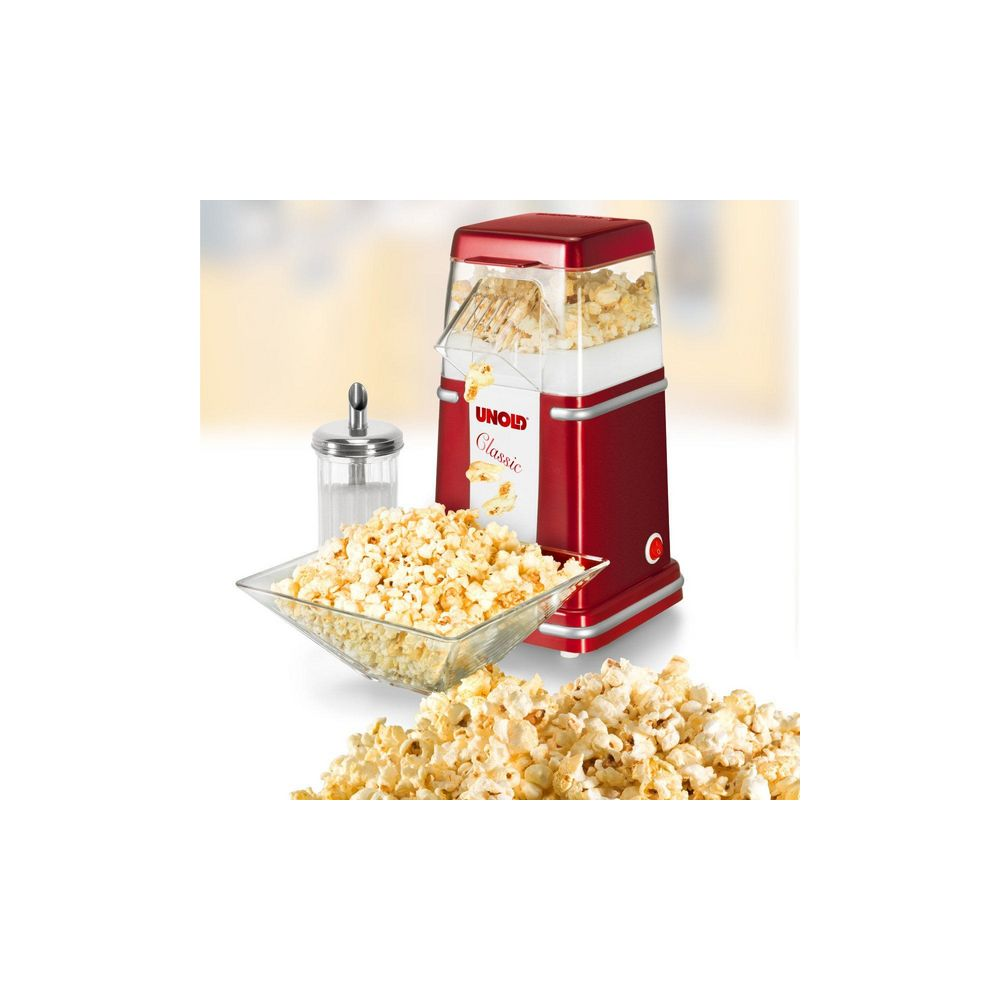 Máquina de palomitas roja con palomitas recién hechas en cuenco y montón.