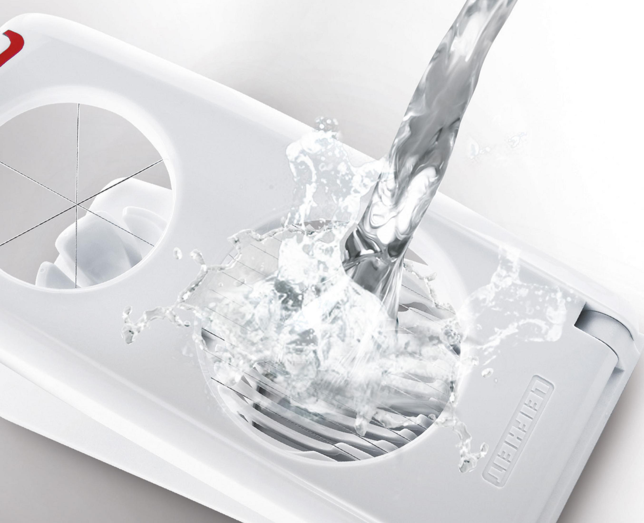 Wasser spritzt auf einen weißen Eierschneider mit Klingen.