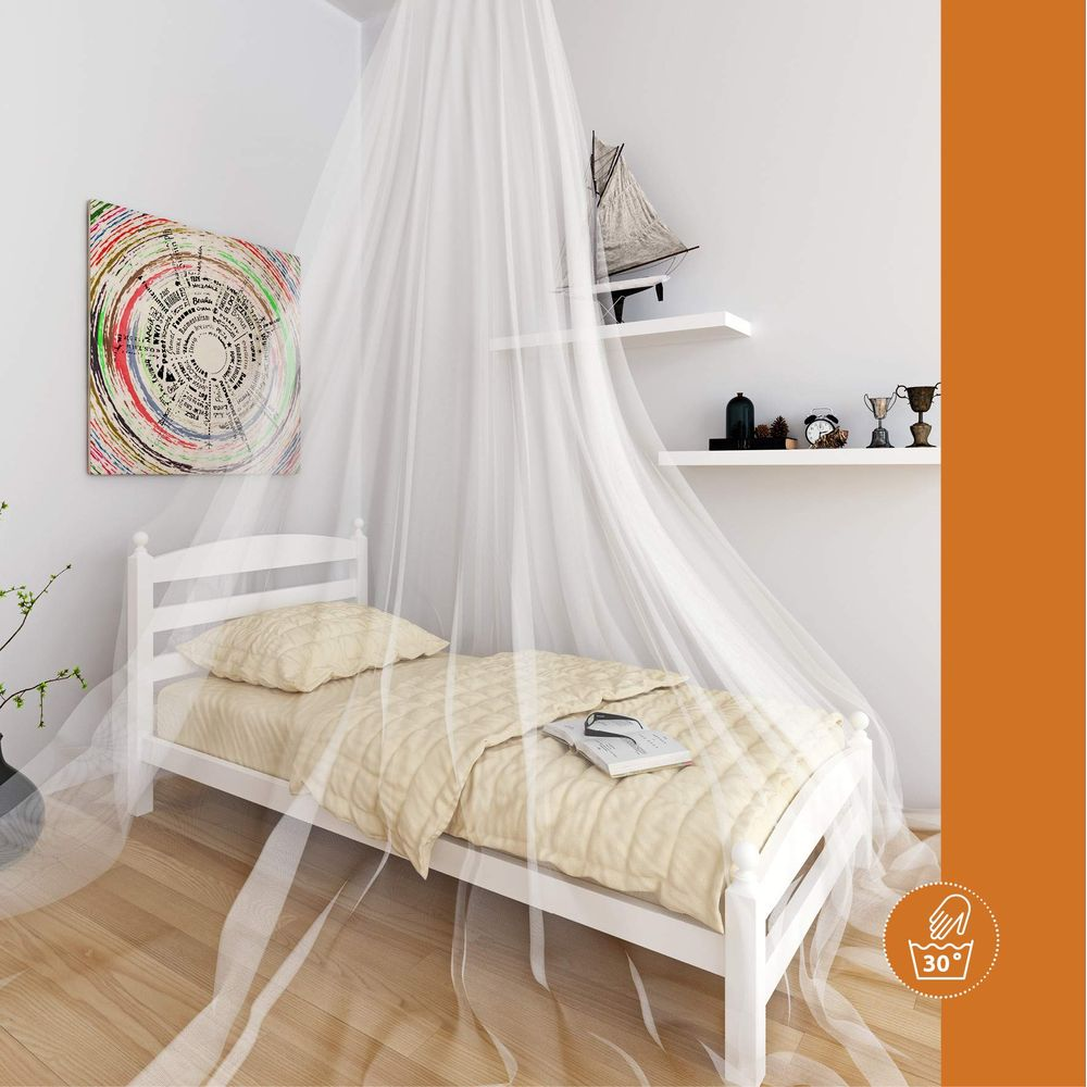 Ein weißes Bett mit einem Moskitonetz, einer Steppdecke und einem Buch.