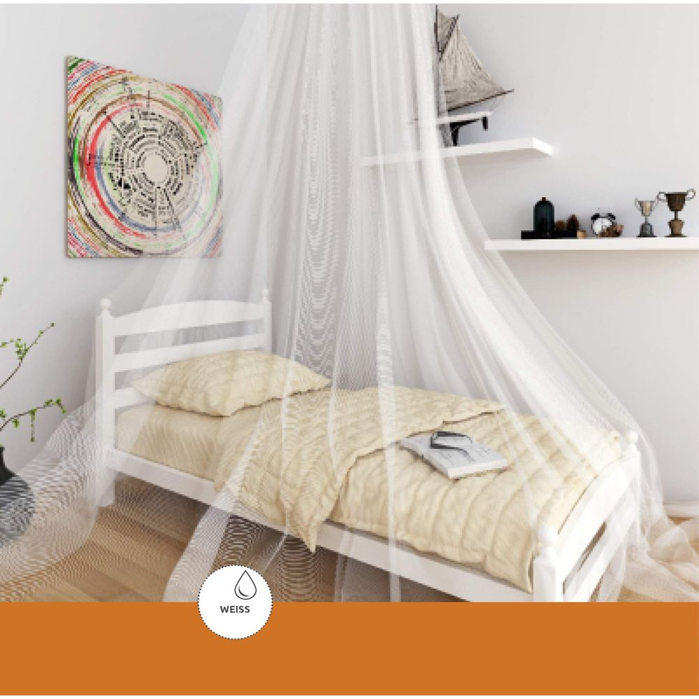 Ein weißes Bett mit gelber Bettwäsche und einem Baldachin. Kunst an der Wand.