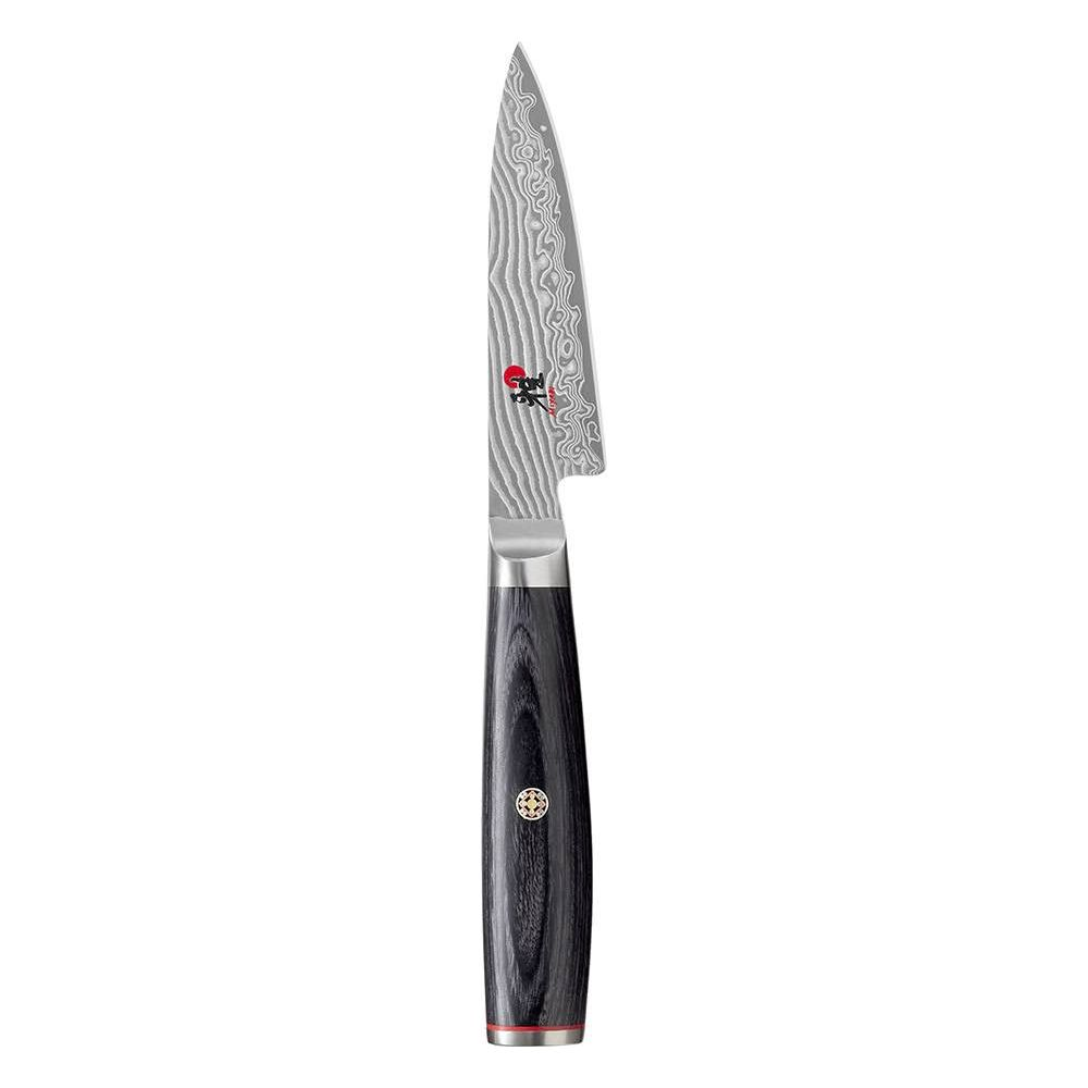 A Damascus steel knife with a black handle and silver accents stands on a white background.