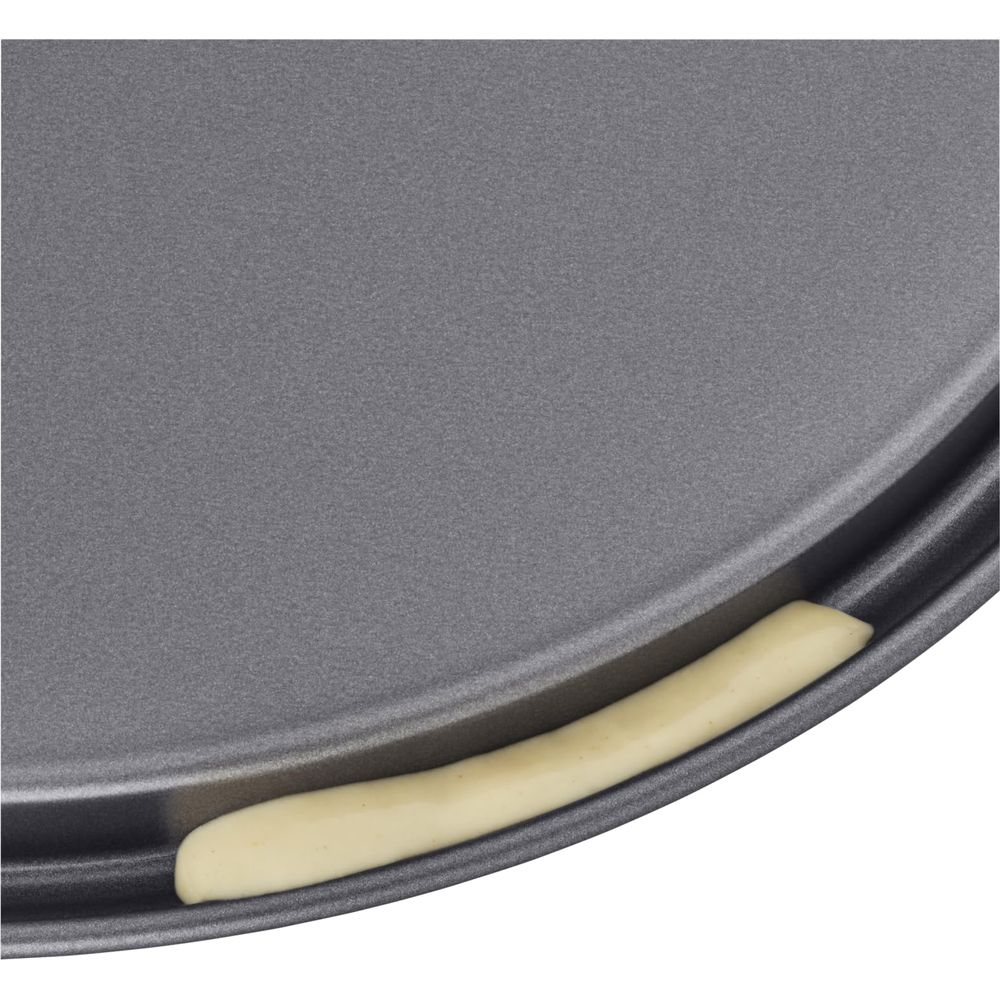 Szara forma do pieczenia z jasnobeżowym brzegiem ciasta.