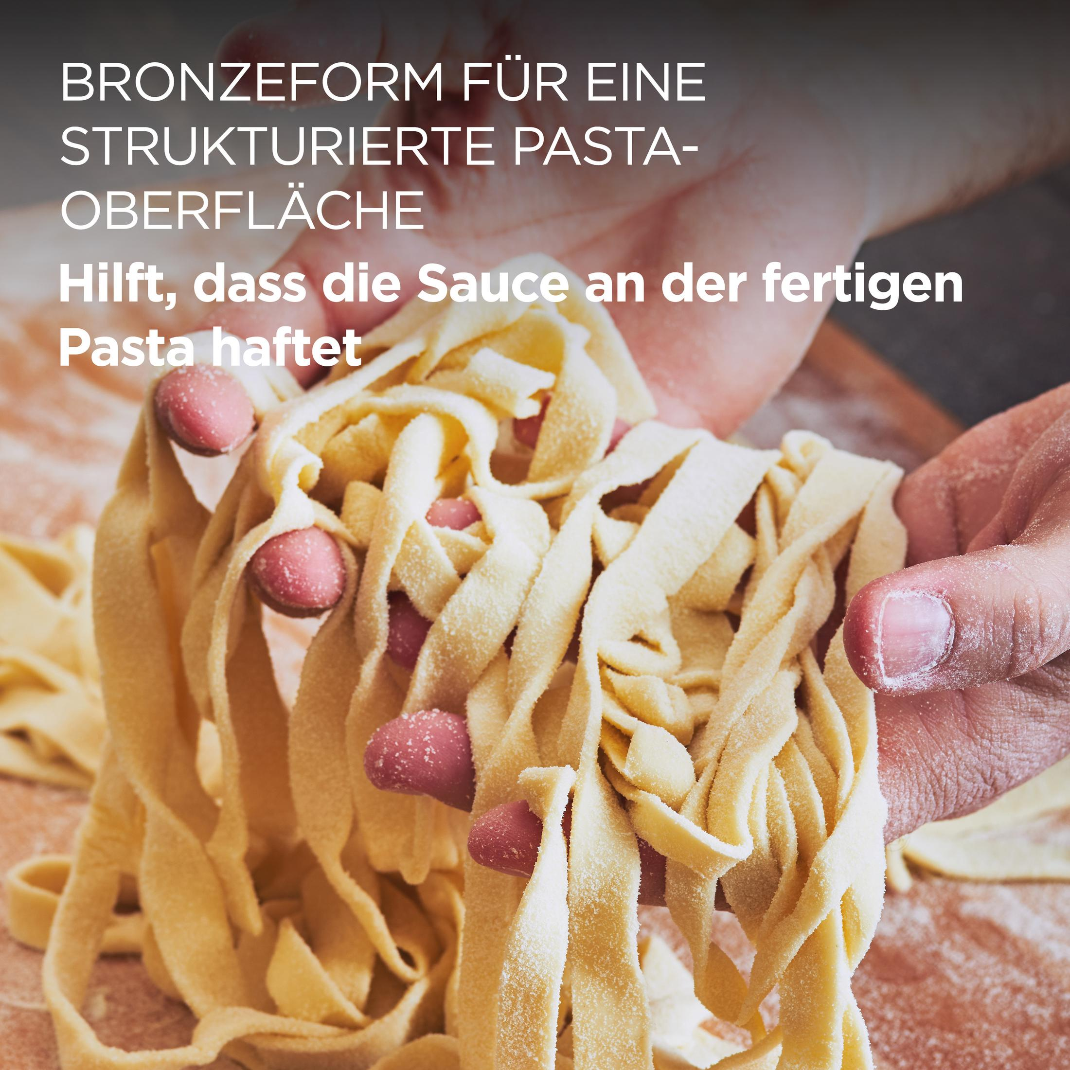 Frische Pasta wird von Händen gehalten, die mit Mehl bestäubt sind.