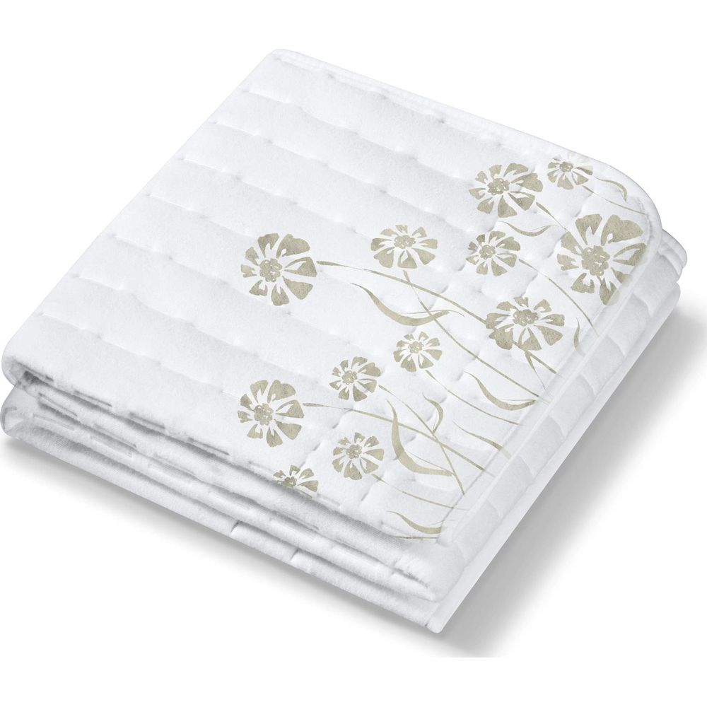 Coperta bianca piegata con motivo floreale beige.