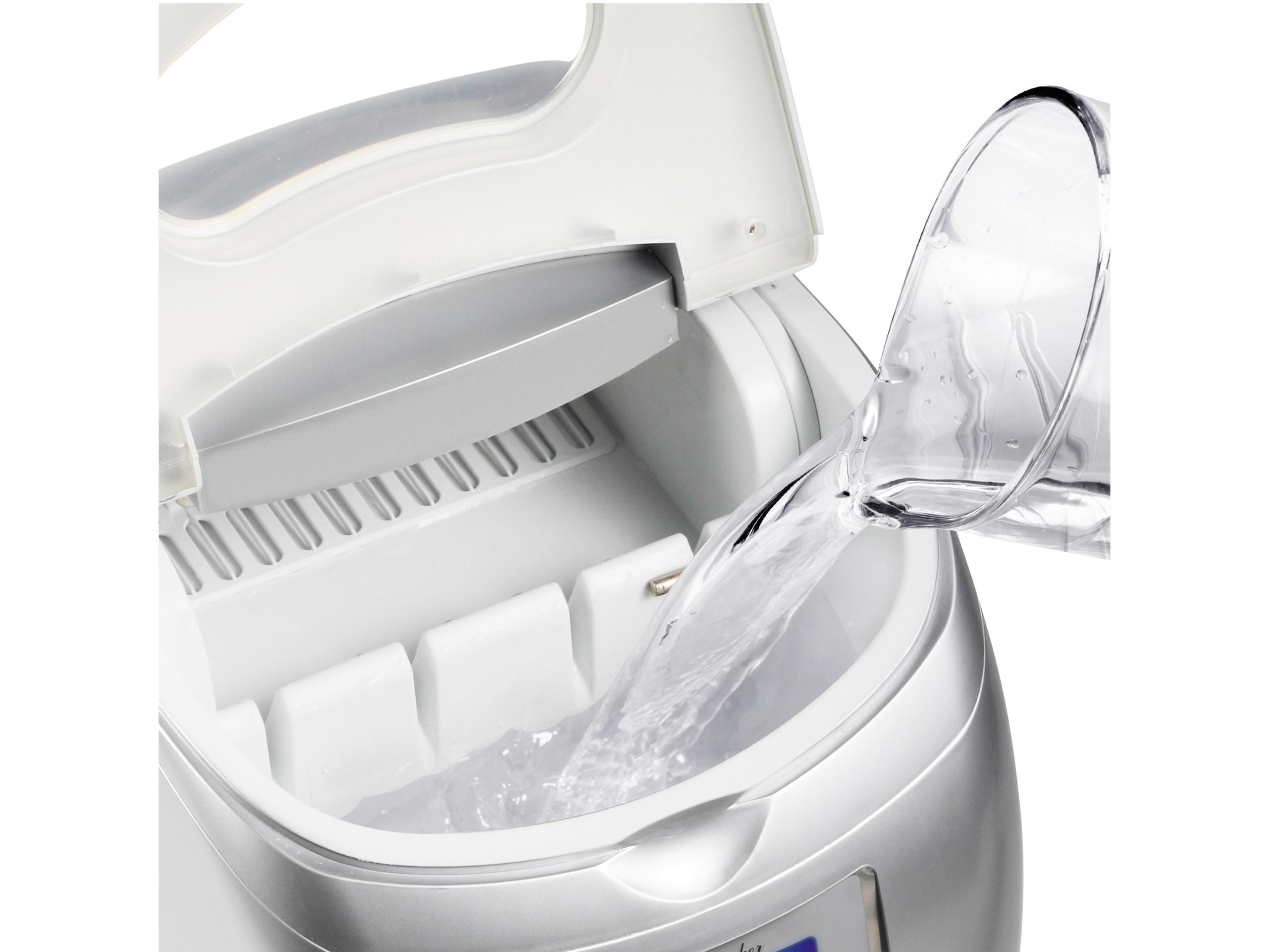 Wasser wird in eine Eismaschine gegossen, die Eiswürfelformen enthält.