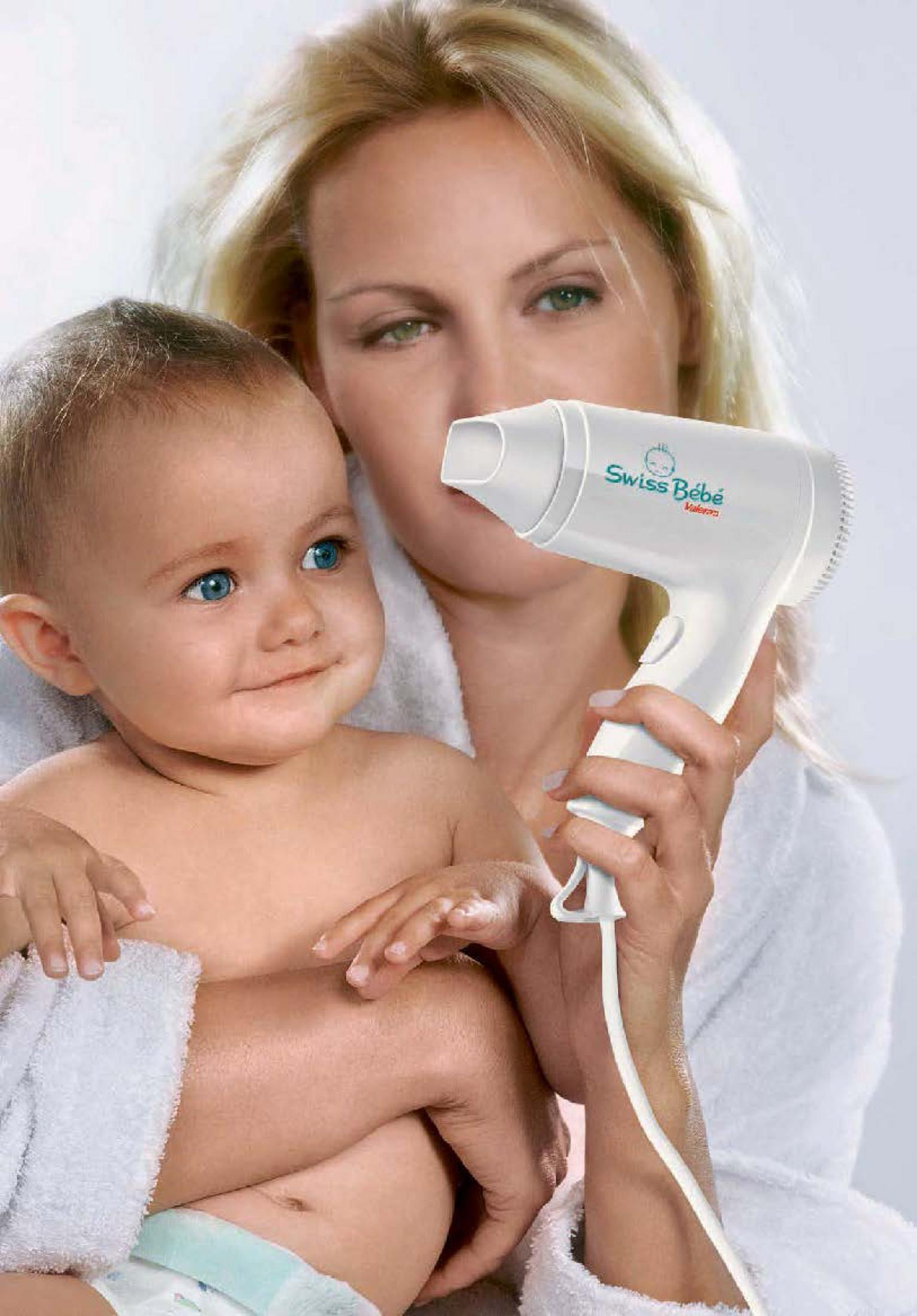 Kobieta trzyma dziecko i białą suszarkę z logo Swiss Bébé.