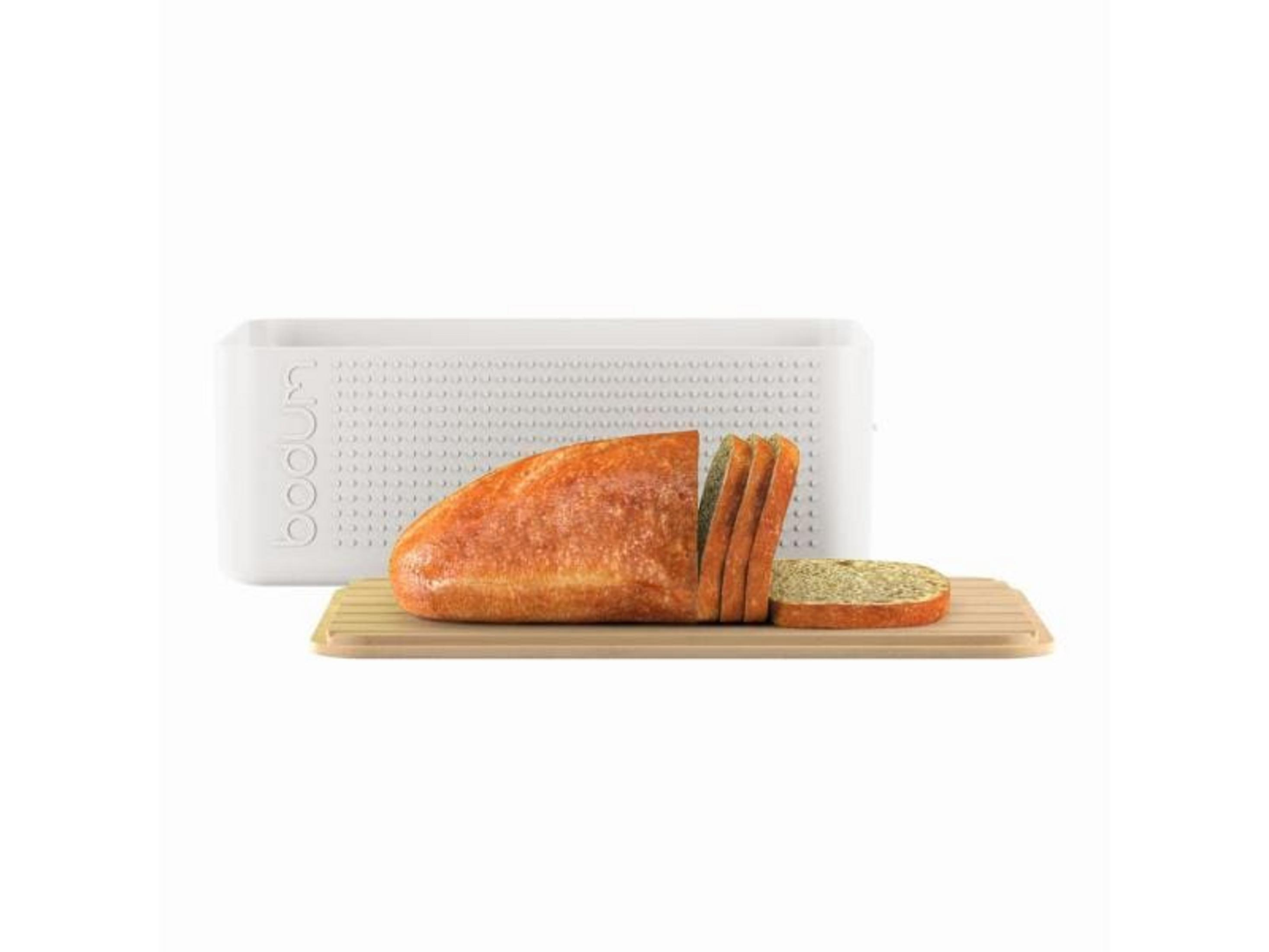 Ein Laib Brot mit Scheiben auf einem Holzbrett und einem weißen Behälter.