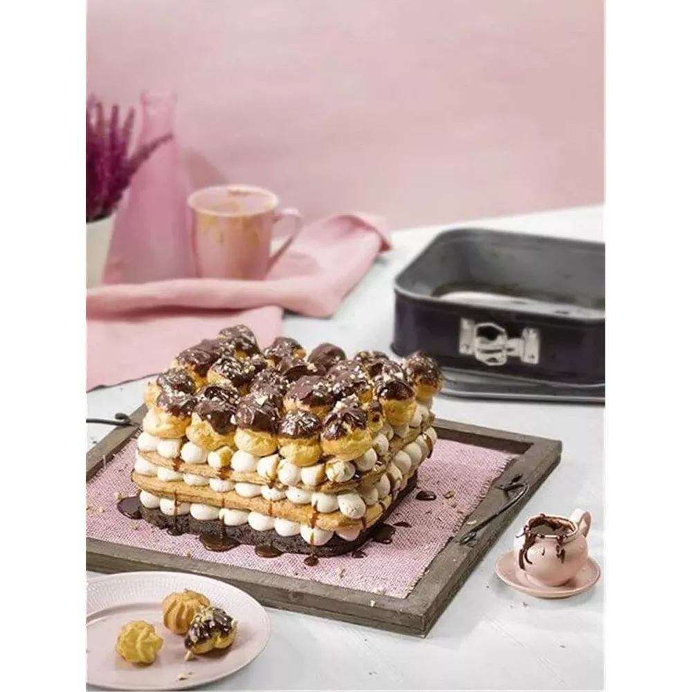 Prostokątny tort z warstwami kremu i ptysi czekoladowych.