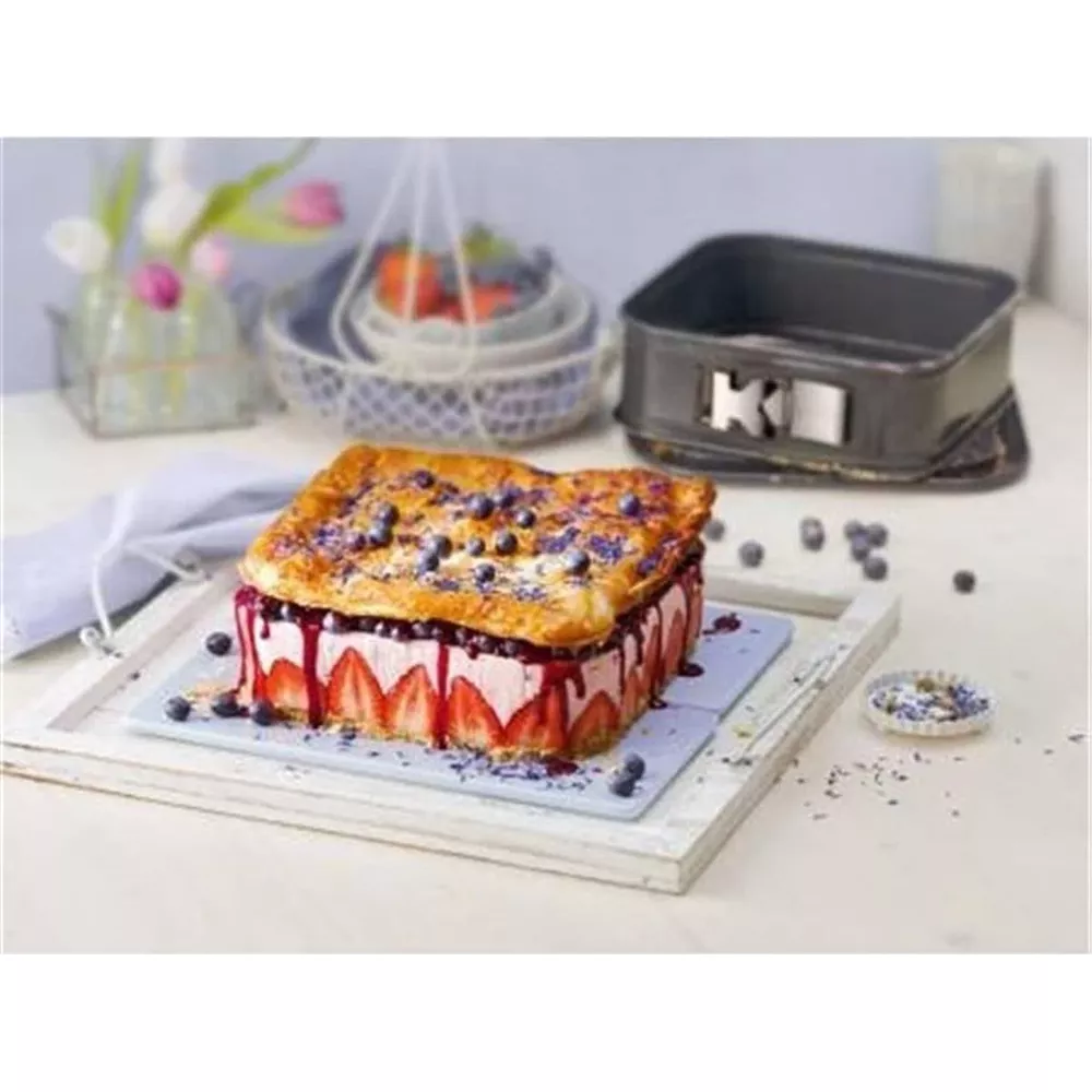 Ciasto z truskawkami, jagodami i ciastem francuskim, obok formy do pieczenia.