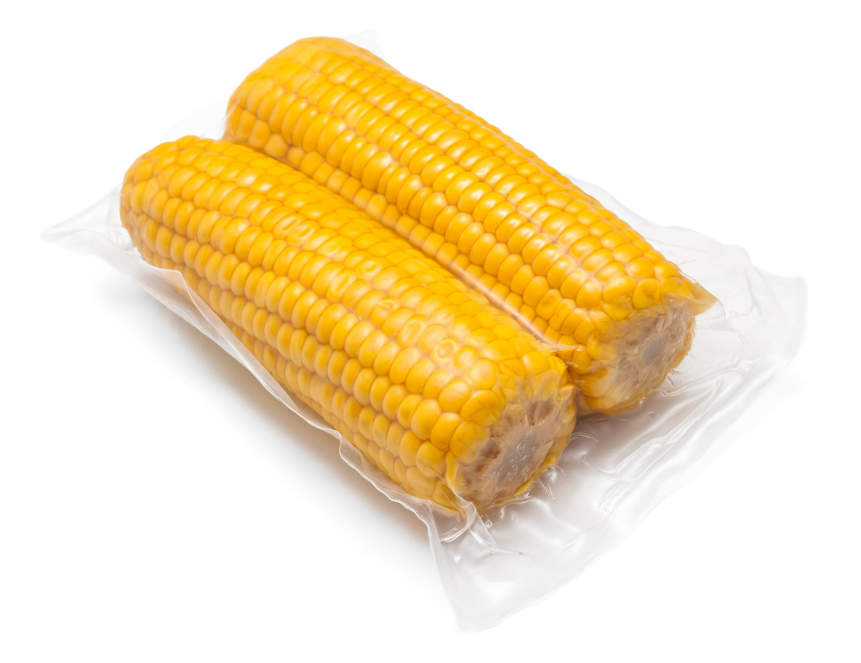 Zwei vakuumverpackte Maiskolben auf weißem Hintergrund.