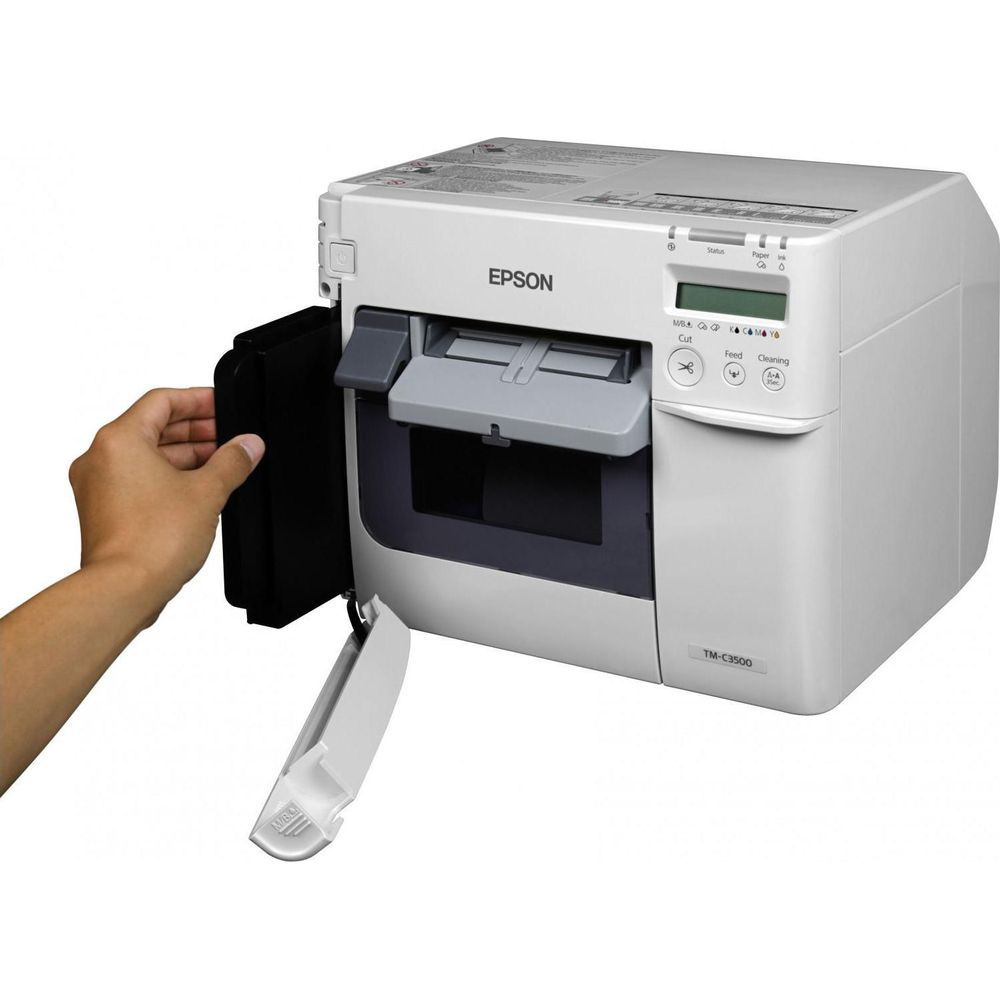 Widoczna drukarka Epson TM-C3500, ręka wkładająca czarny element.