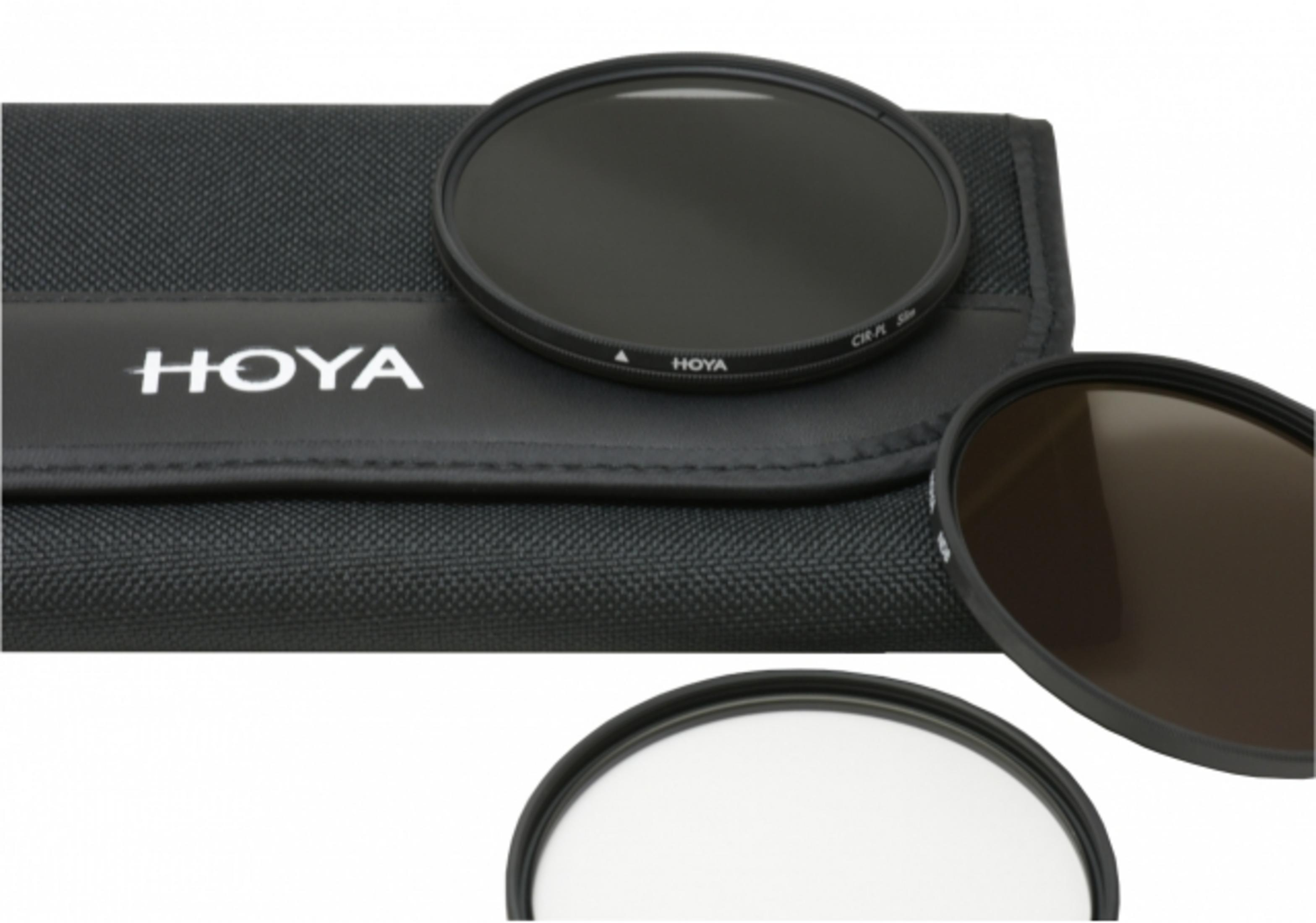 Drie Hoya camerafilters liggen naast een zwarte stoffen etui met Hoya-logo.