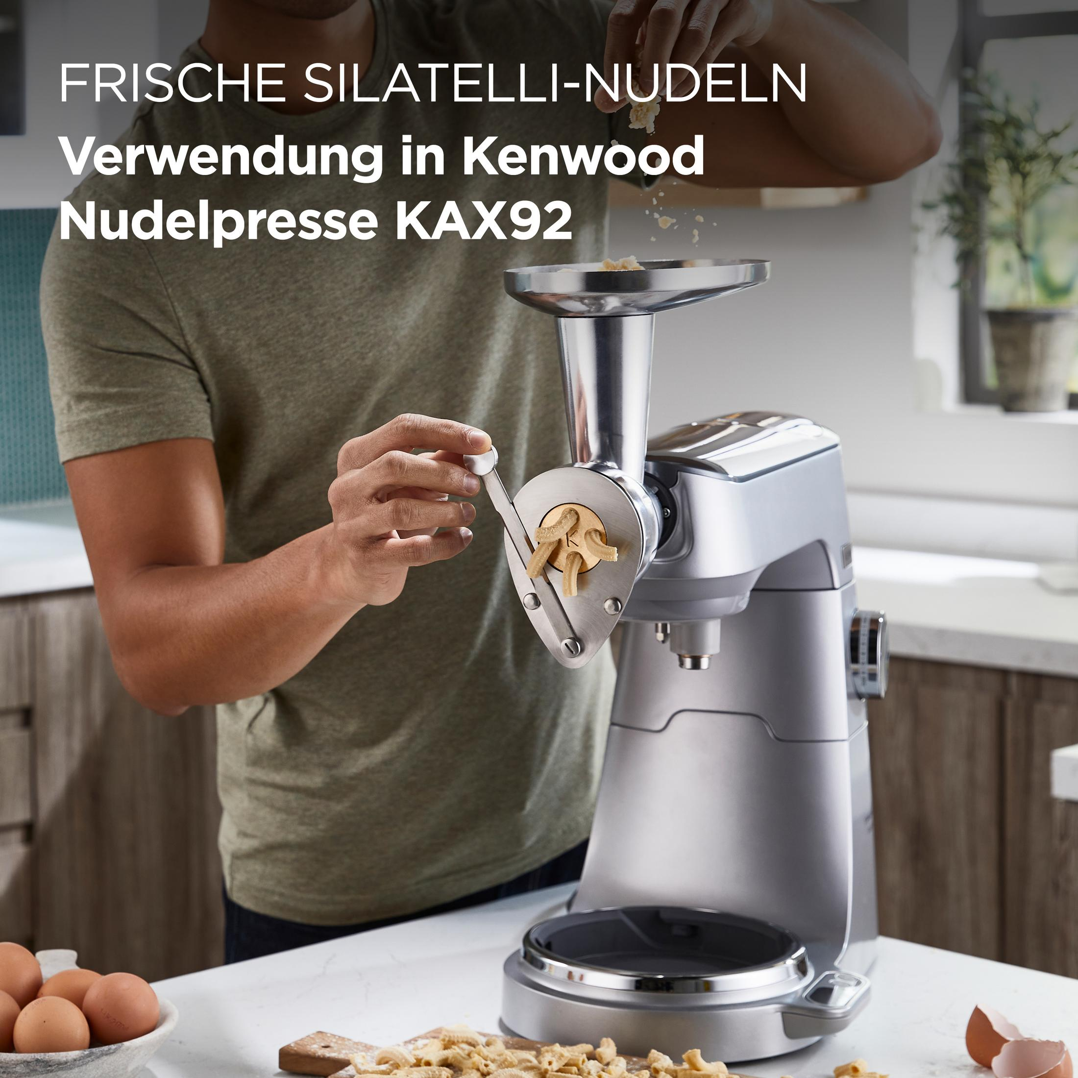 Uomo usa macchina per pasta Kenwood con pasta silatelli, uova e impasto.