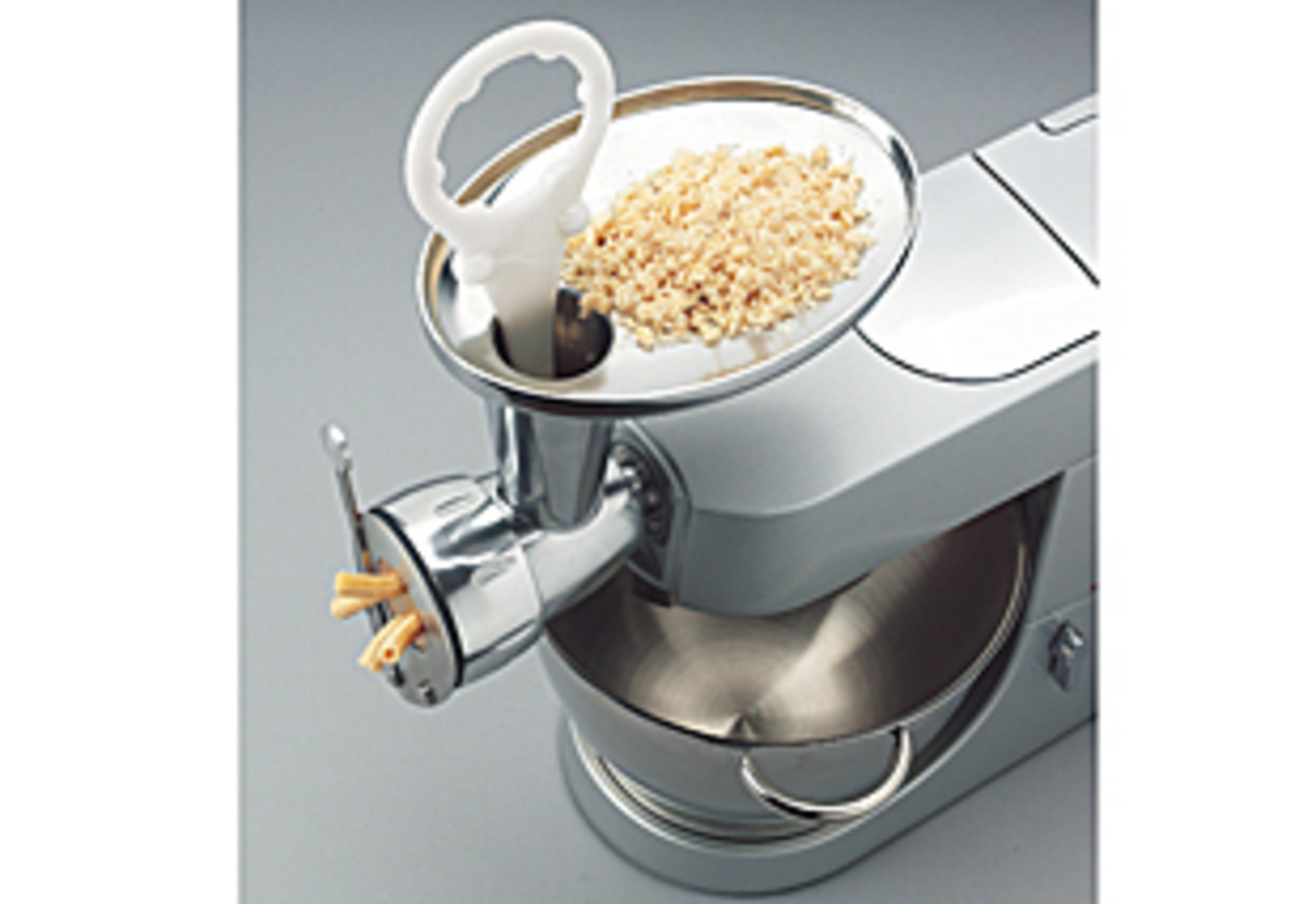 Un robot culinaire avec accessoire à pâtes, produisant des pâtes fraîches.